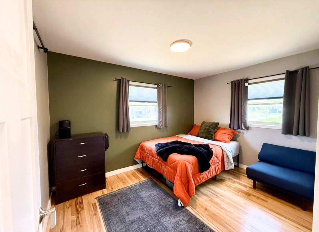 Light wood-finish flooring, dual windows, and ceiling-mounted lighting fixture
