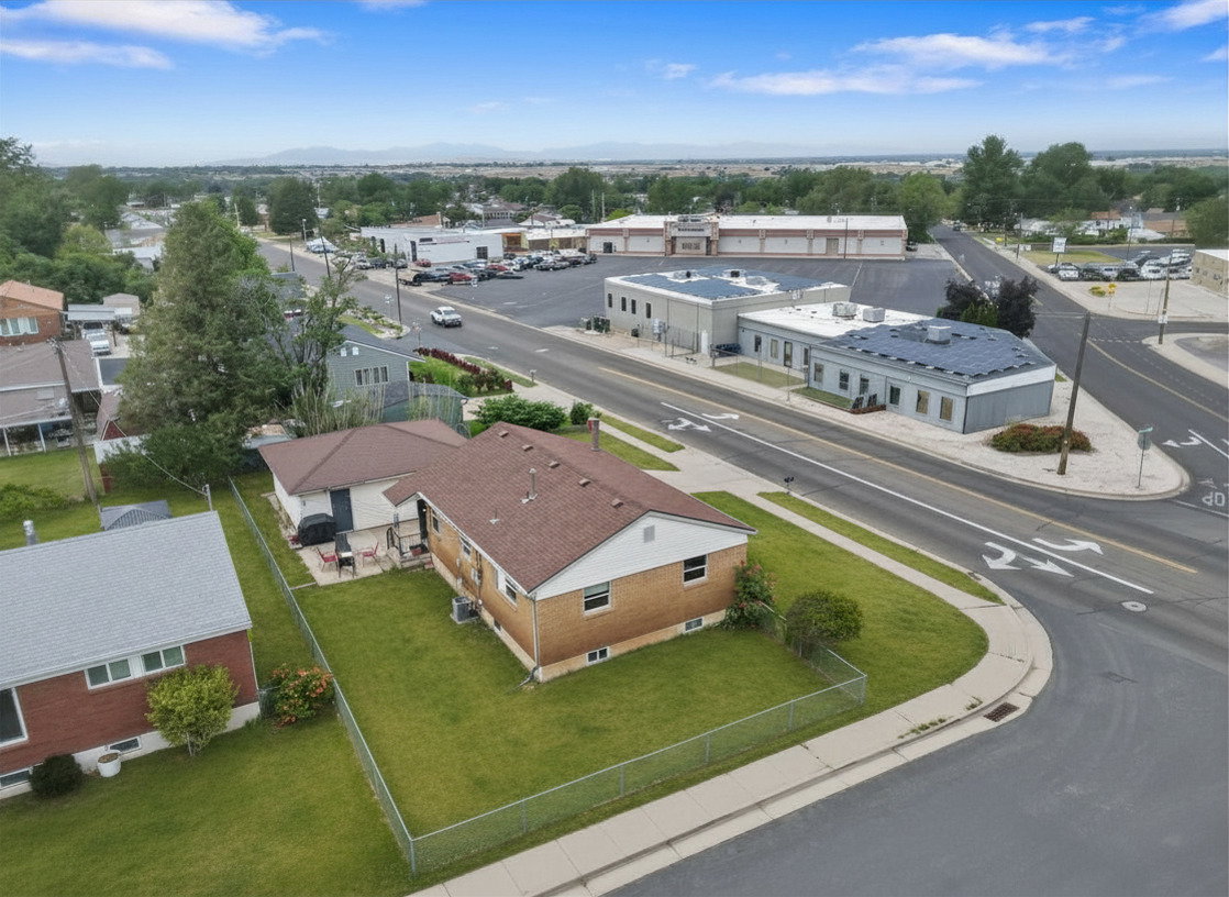Expansive corner lot featuring a brick exterior and a brown shingle roof