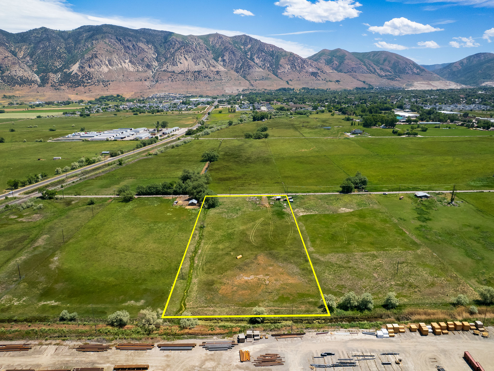 Expansive grass lot featuring a flat topography and distant mountain backdrop