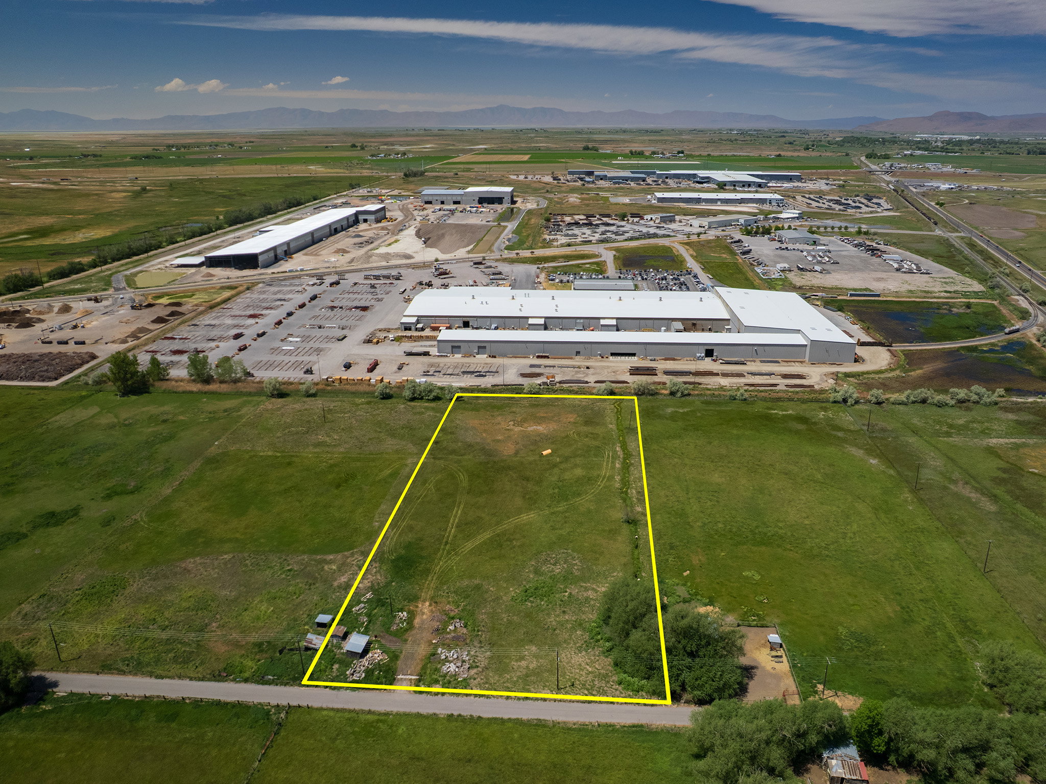 Expansive rectangular parcel featuring a grass field and a small cluster of trees