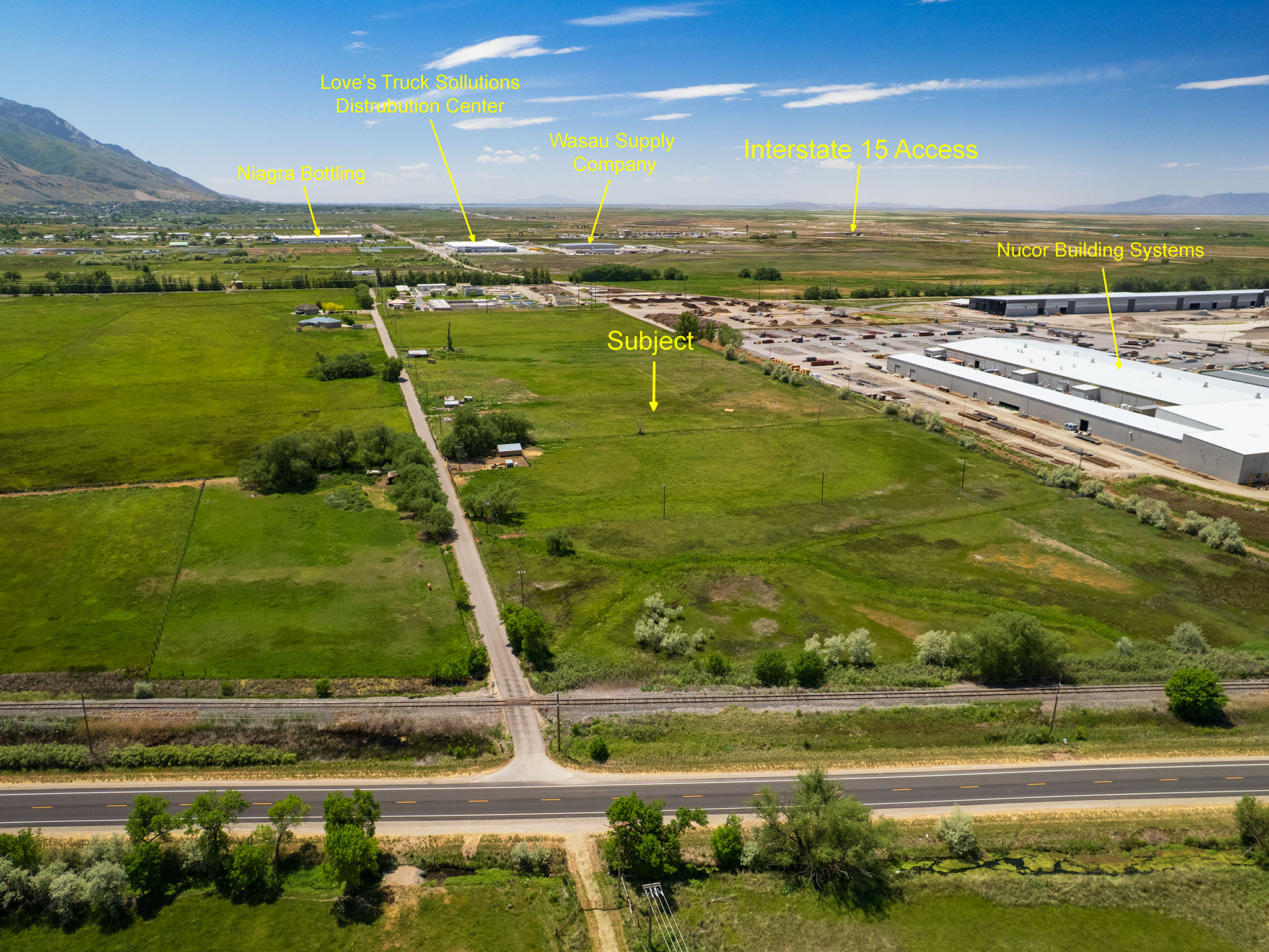 Expansive land parcel featuring open fields and direct road frontage