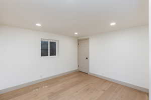 Room featuring light wood-finish flooring, white walls, and recessed ceiling lighting