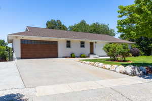 White exterior with a prominent wood-finish garage door