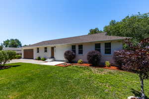 Ranch-style exterior with a white brick facade and a brown shingle roof