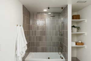 Shower-over-tub with full-height vertical tile surround, rain showerhead, and handheld spray