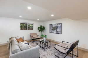 Bright living area featuring recessed lighting, light wood-finish flooring, a contemporary window, and clean white walls