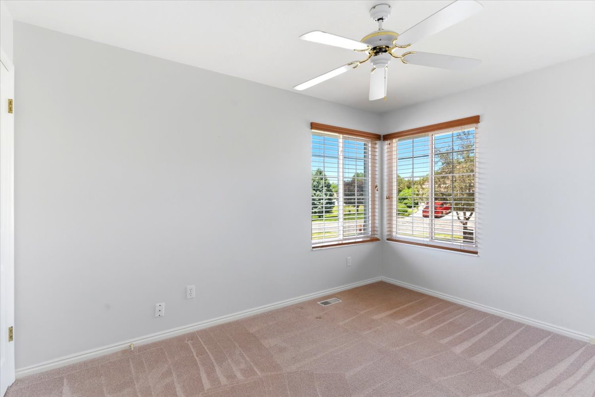 Second Bedroom. Corner window arrangement featuring horizontal blinds and wood-finish trim