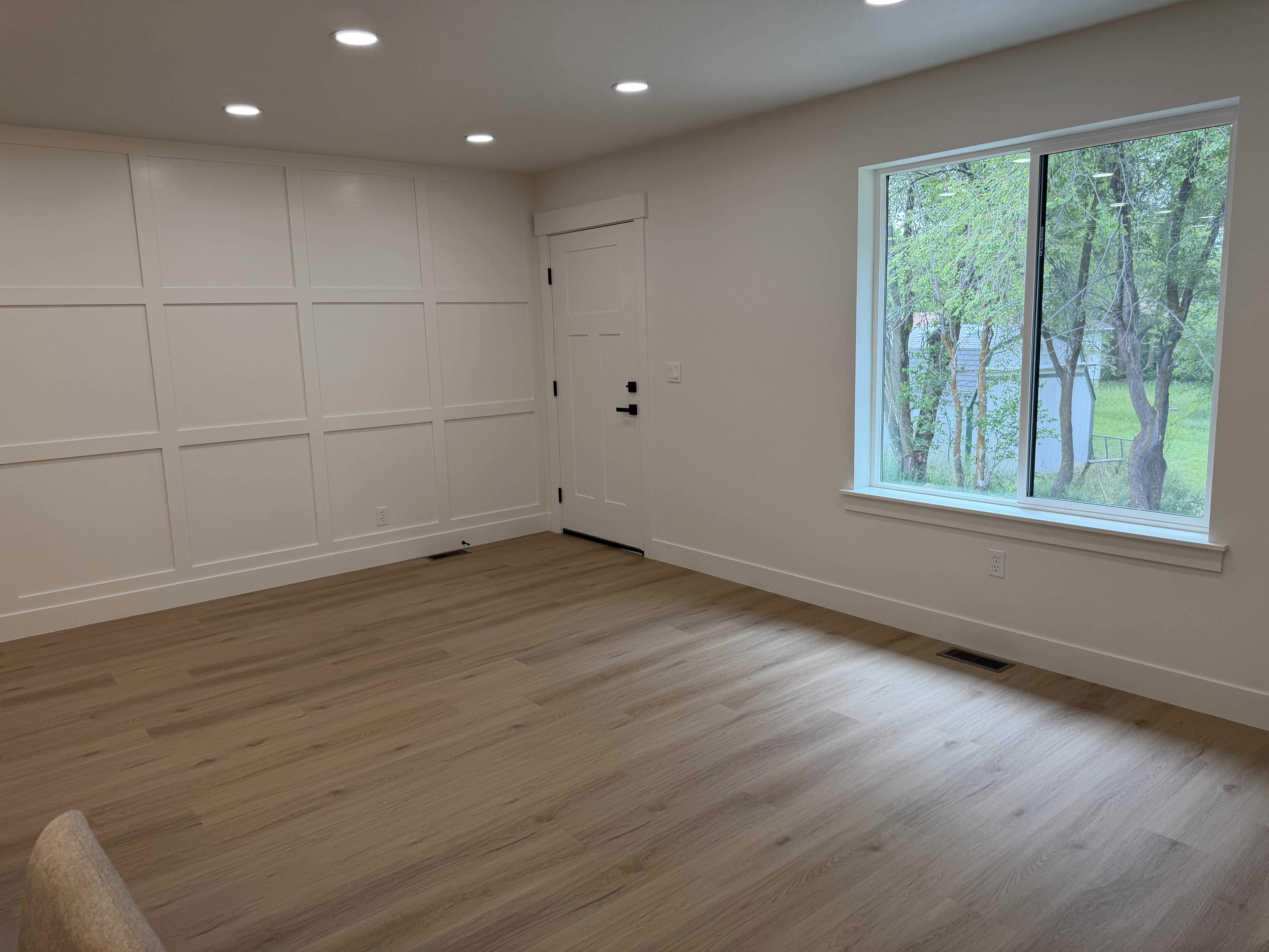 Bright interior space featuring a grid accent wall, recessed lighting, and light wood-finish flooring
