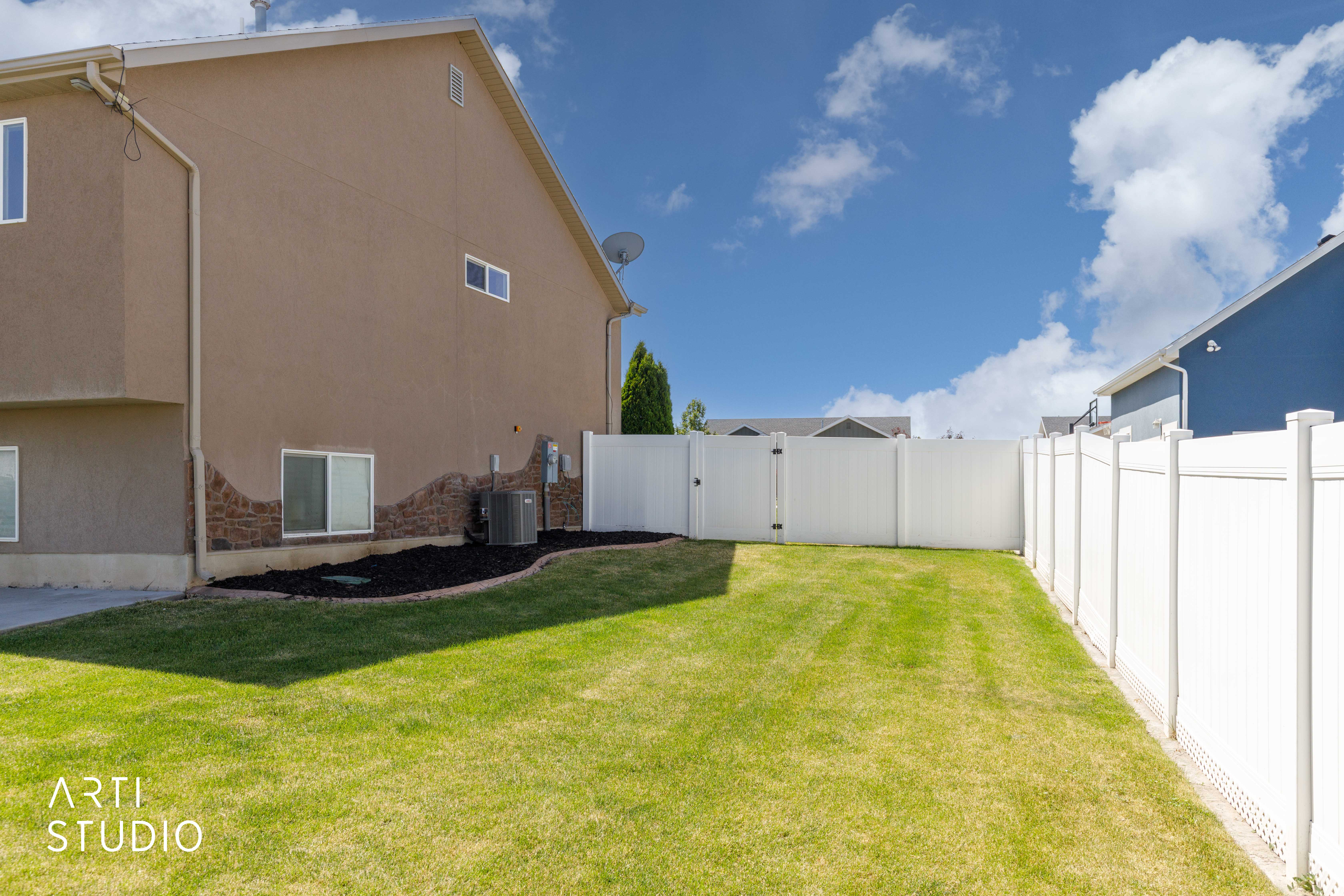 Expansive backyard featuring a manicured lawn and a full vinyl privacy fence