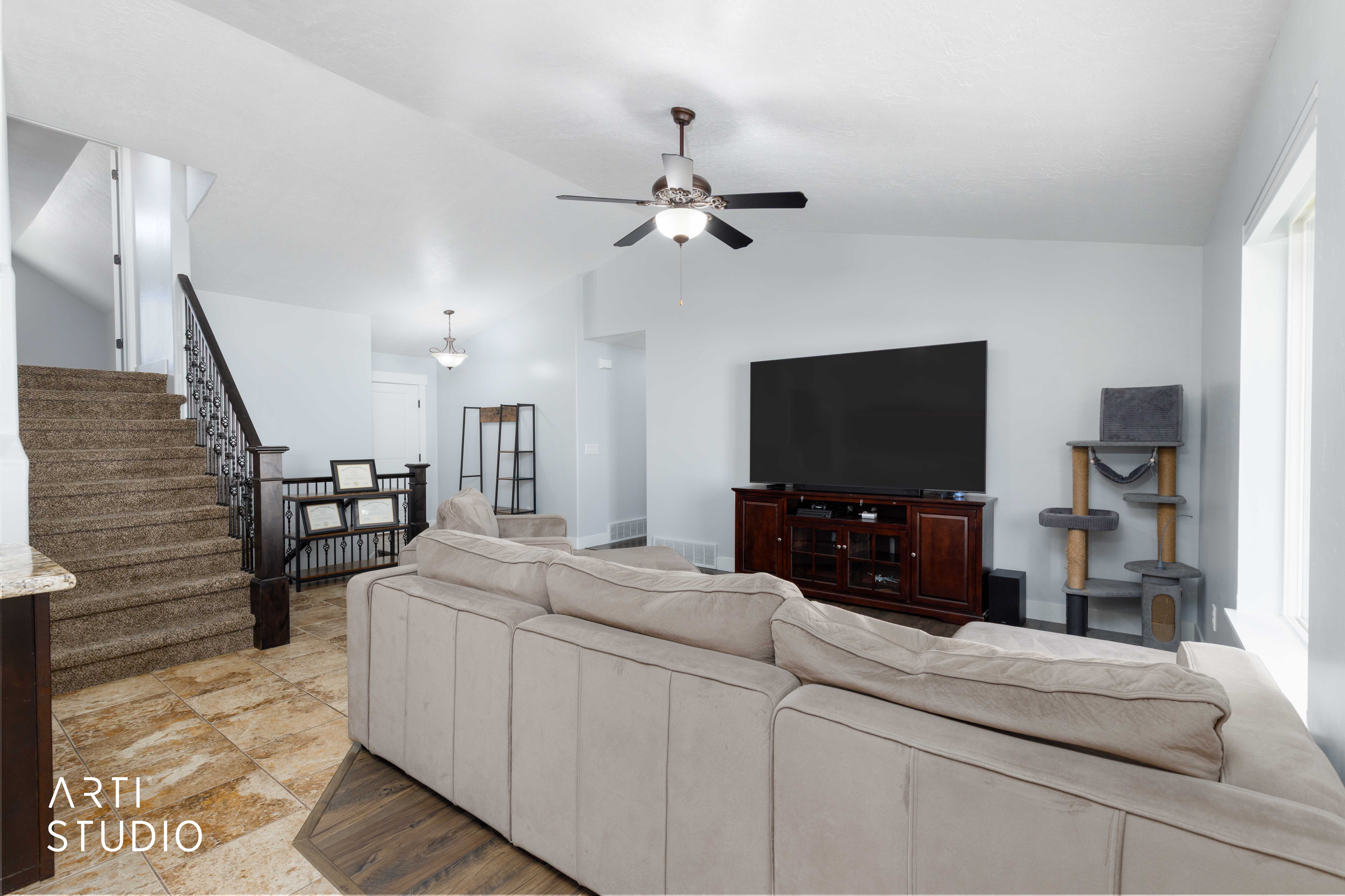 Open-concept living area with tile flooring and wood-finish flooring