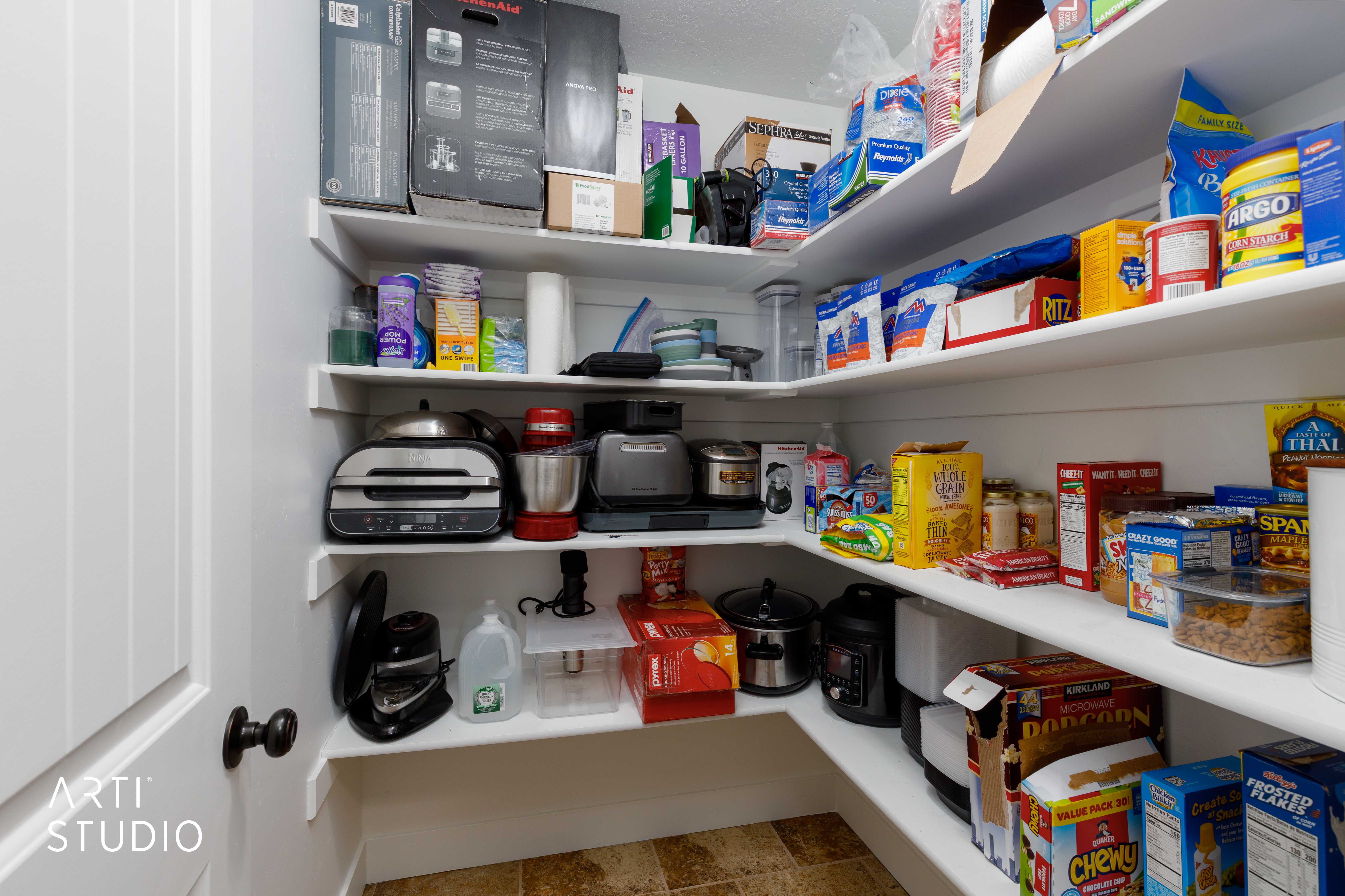 Spacious pantry featuring multiple white built-in shelves, offering extensive storage