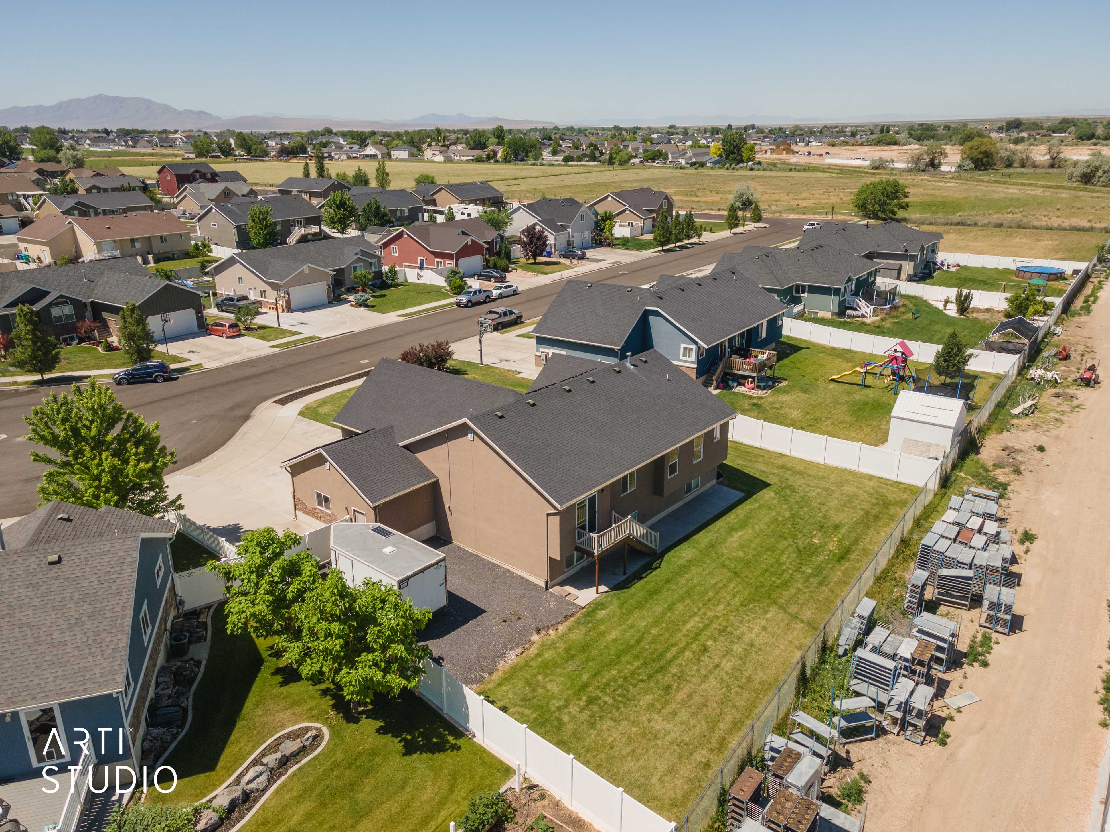 Expansive green lawn with a white privacy fence