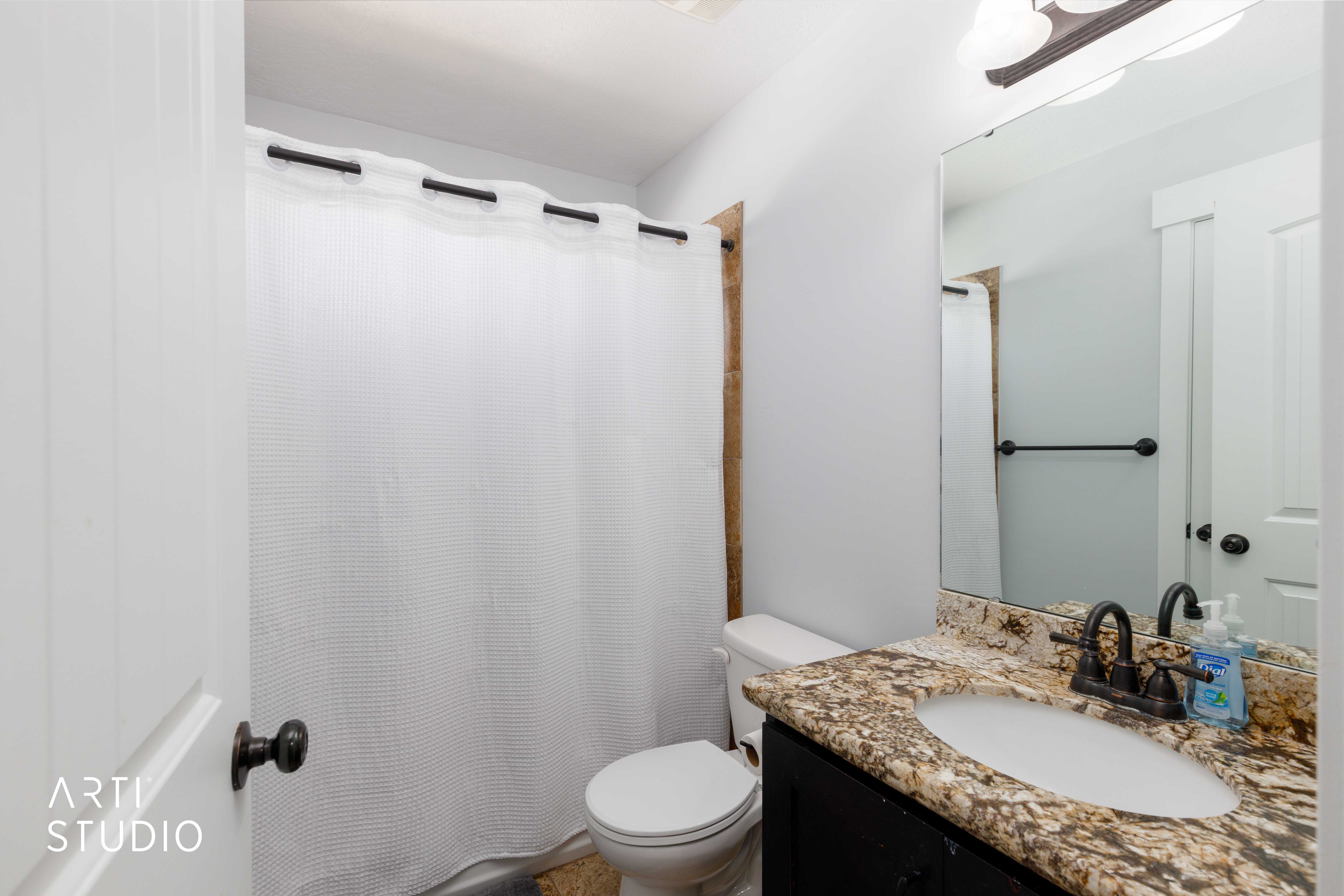 Bathroom featuring a vanity with a patterned countertop, integrated sink, and dark bronze-finish fixtures