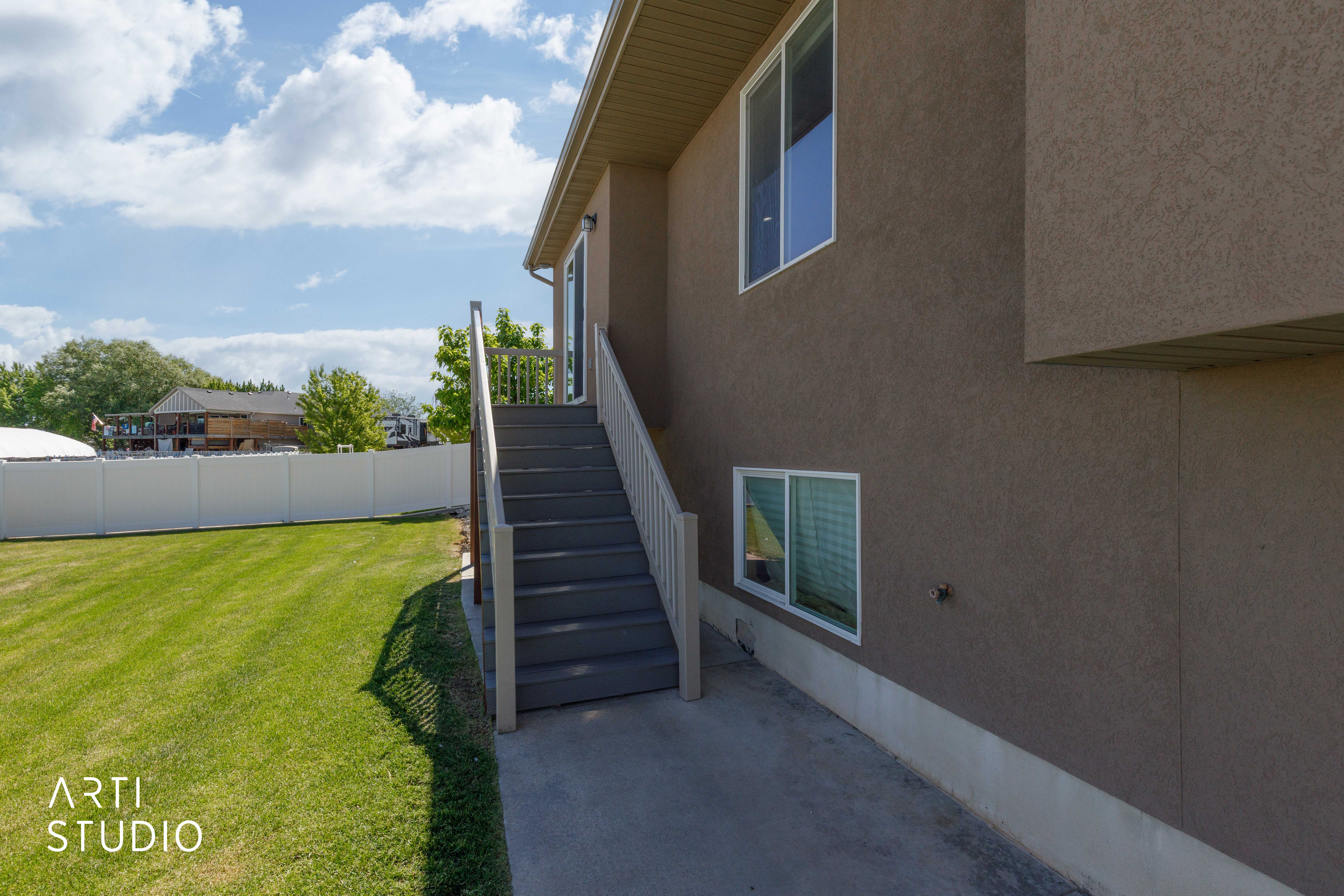 Expansive green lawn with a white privacy fence