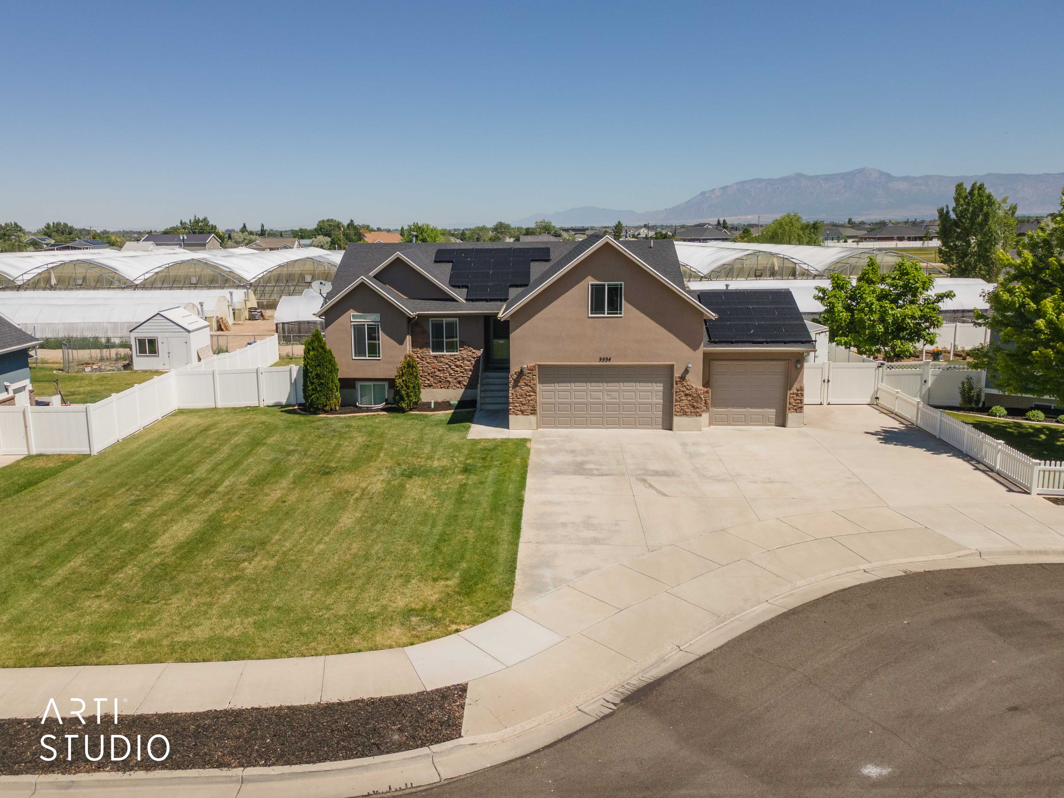 Stucco exterior with stone accenting, a two-car garage, and an additional single-car garage