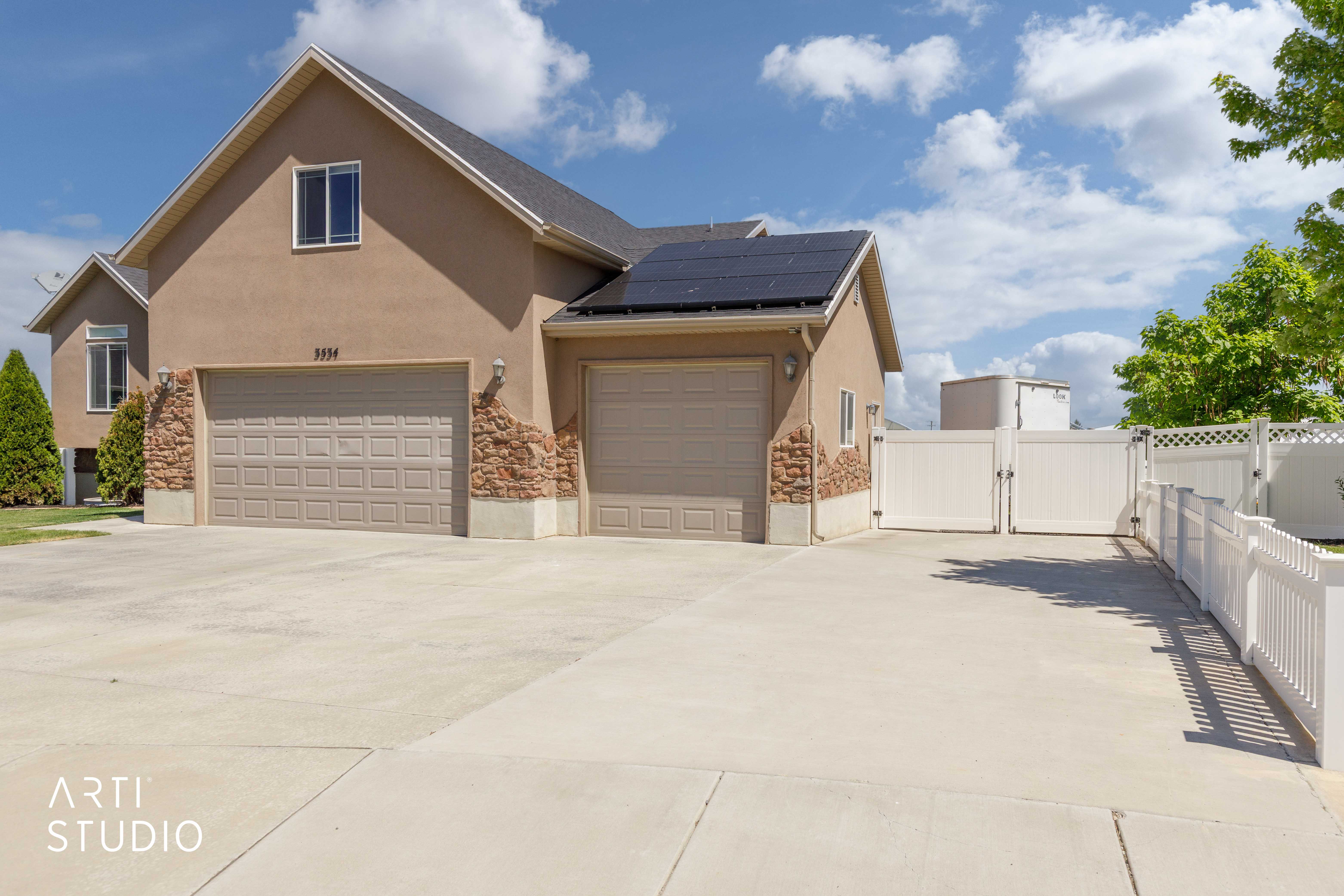 Stucco exterior with stone accents and two garage doors