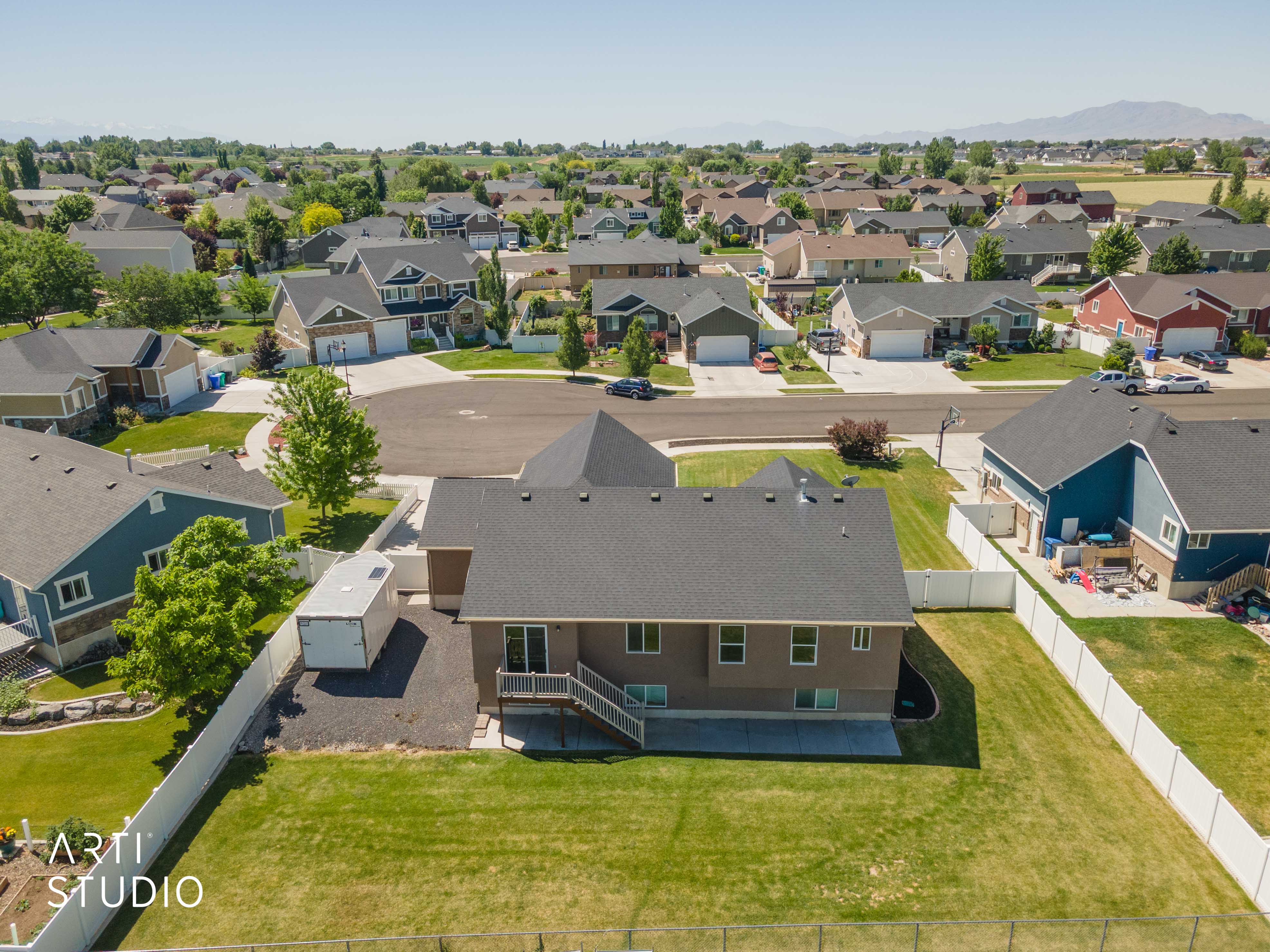 Expansive rear yard featuring a manicured lawn, a privacy fence, and a multi-level deck