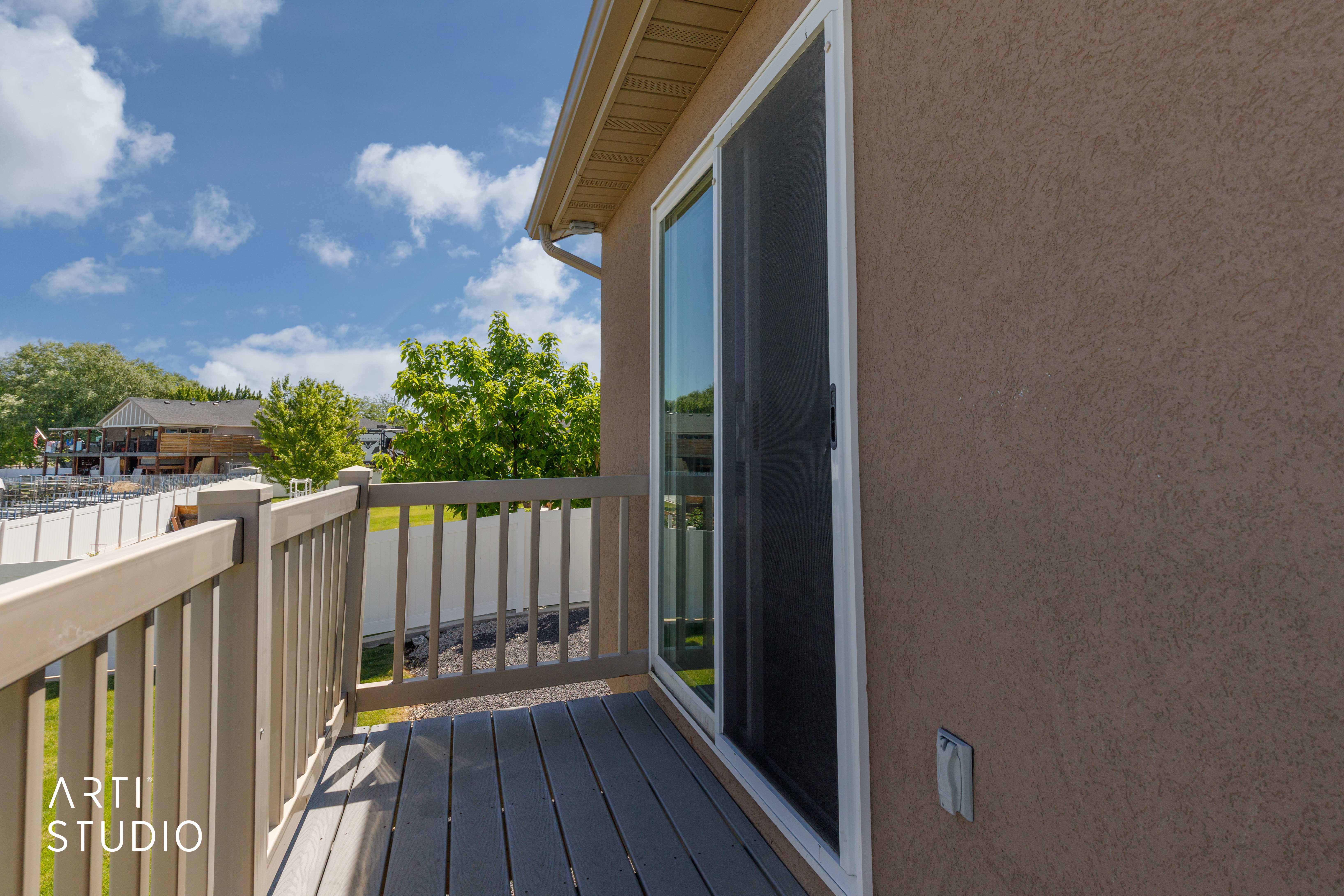 Private balcony with neutral-toned composite decking, complementing a stucco exterior