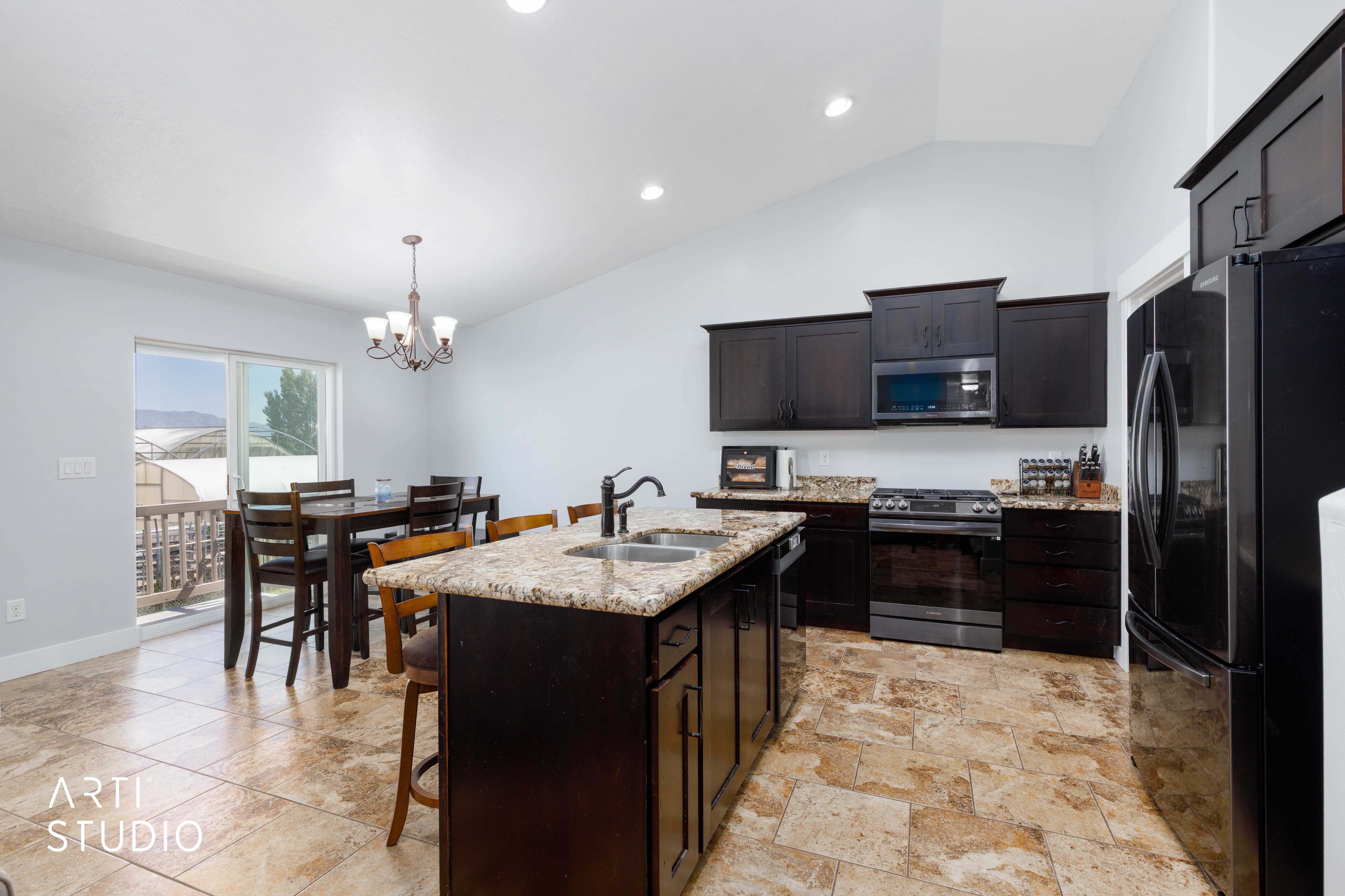 Open-concept kitchen and dining area featuring a vaulted ceiling and tiled flooring