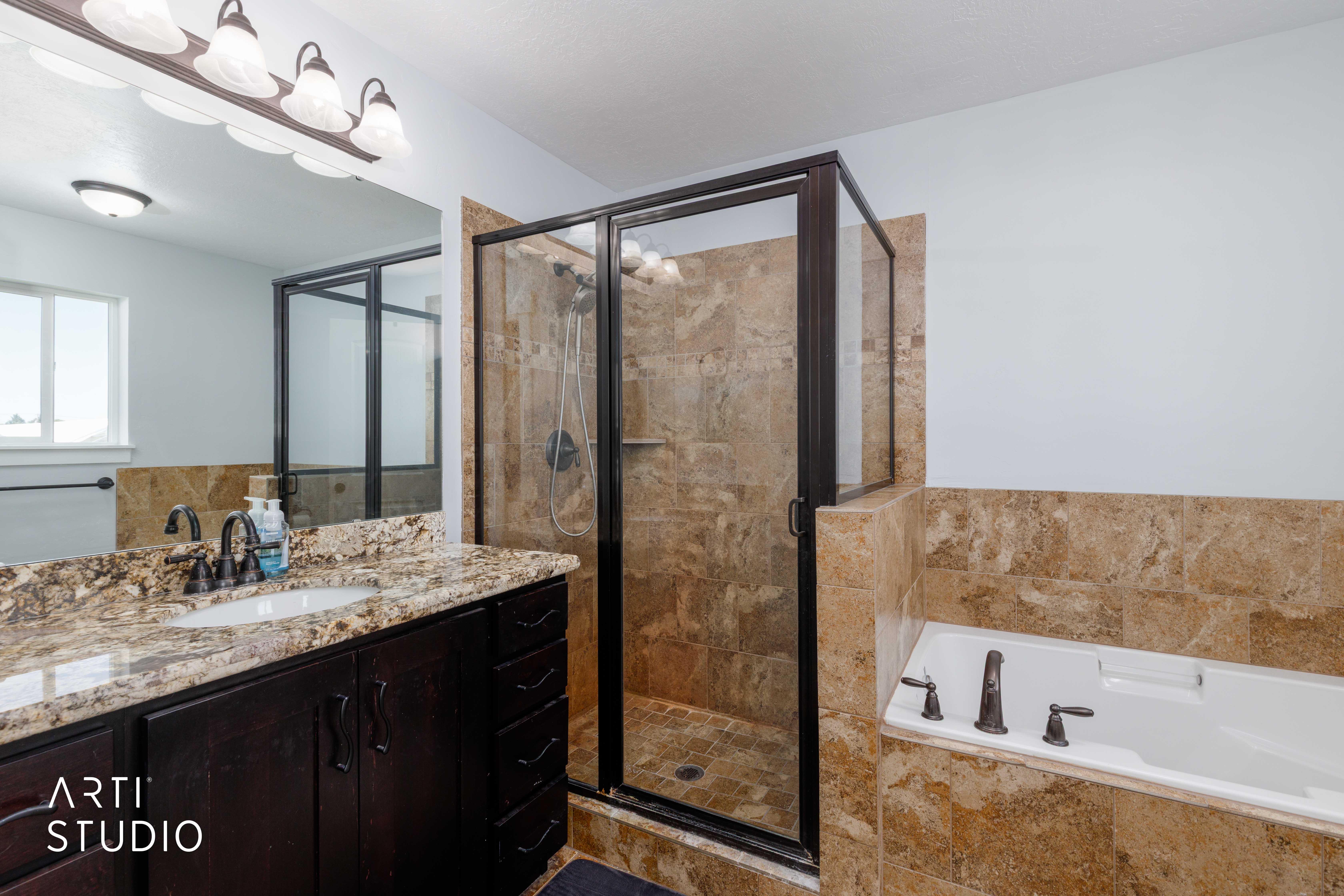 Shower and soaking tub combination featuring natural stone-look tile surrounds