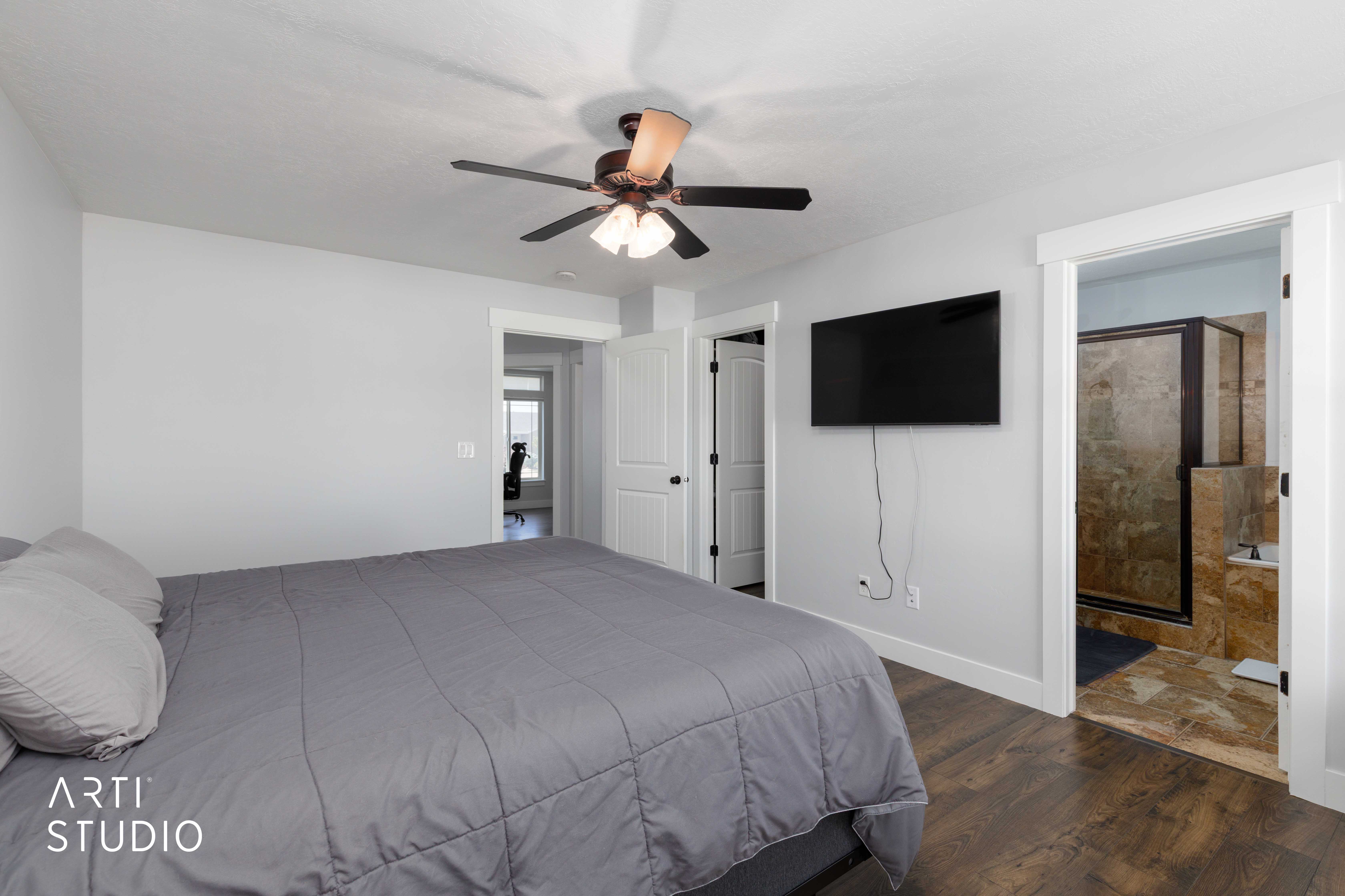 Interior room featuring wood-finish flooring, a ceiling fan with integrated lighting, and light gray walls