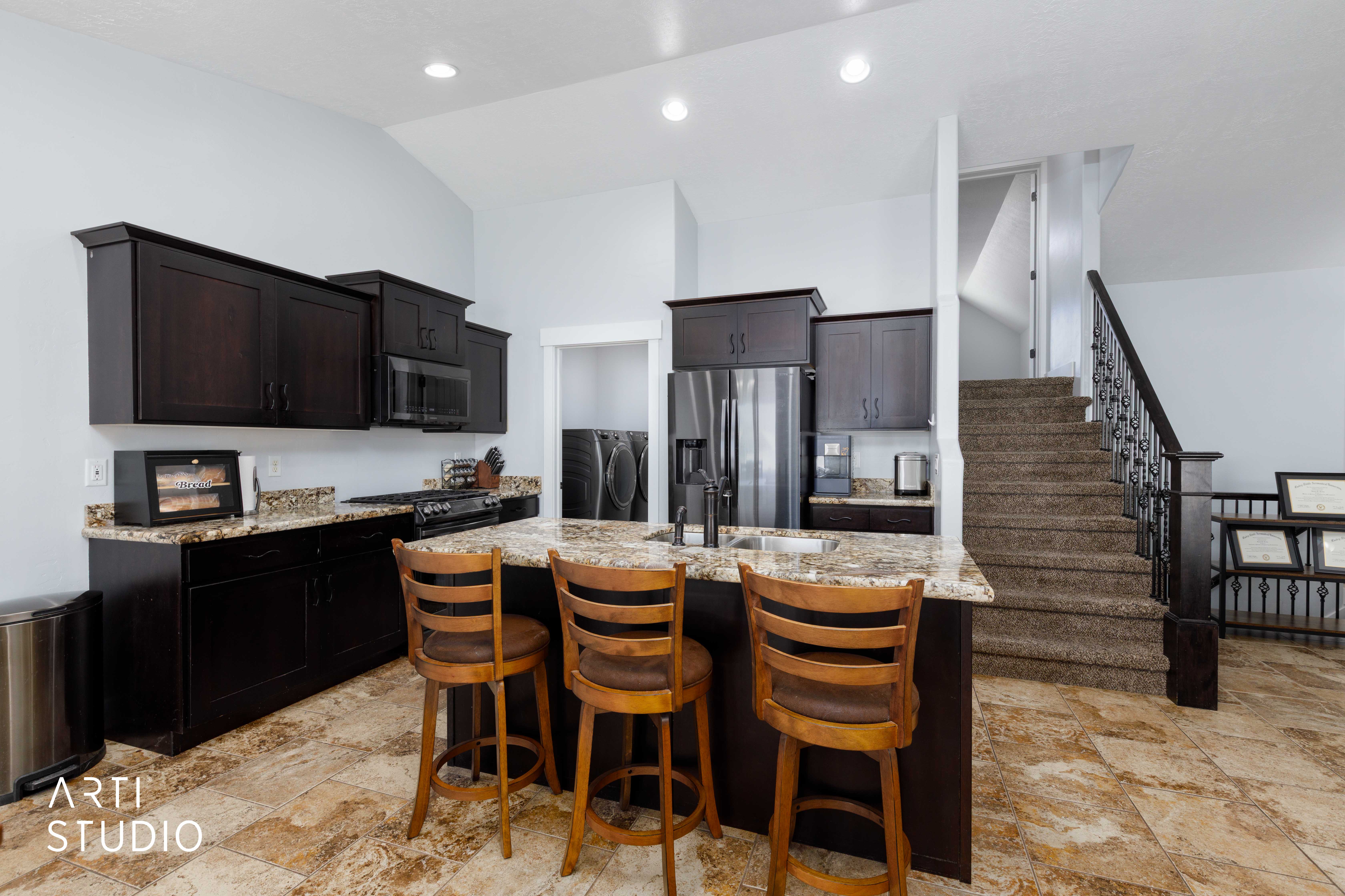 Kitchen featuring dark wood cabinetry, granite countertops, and stainless steel appliances