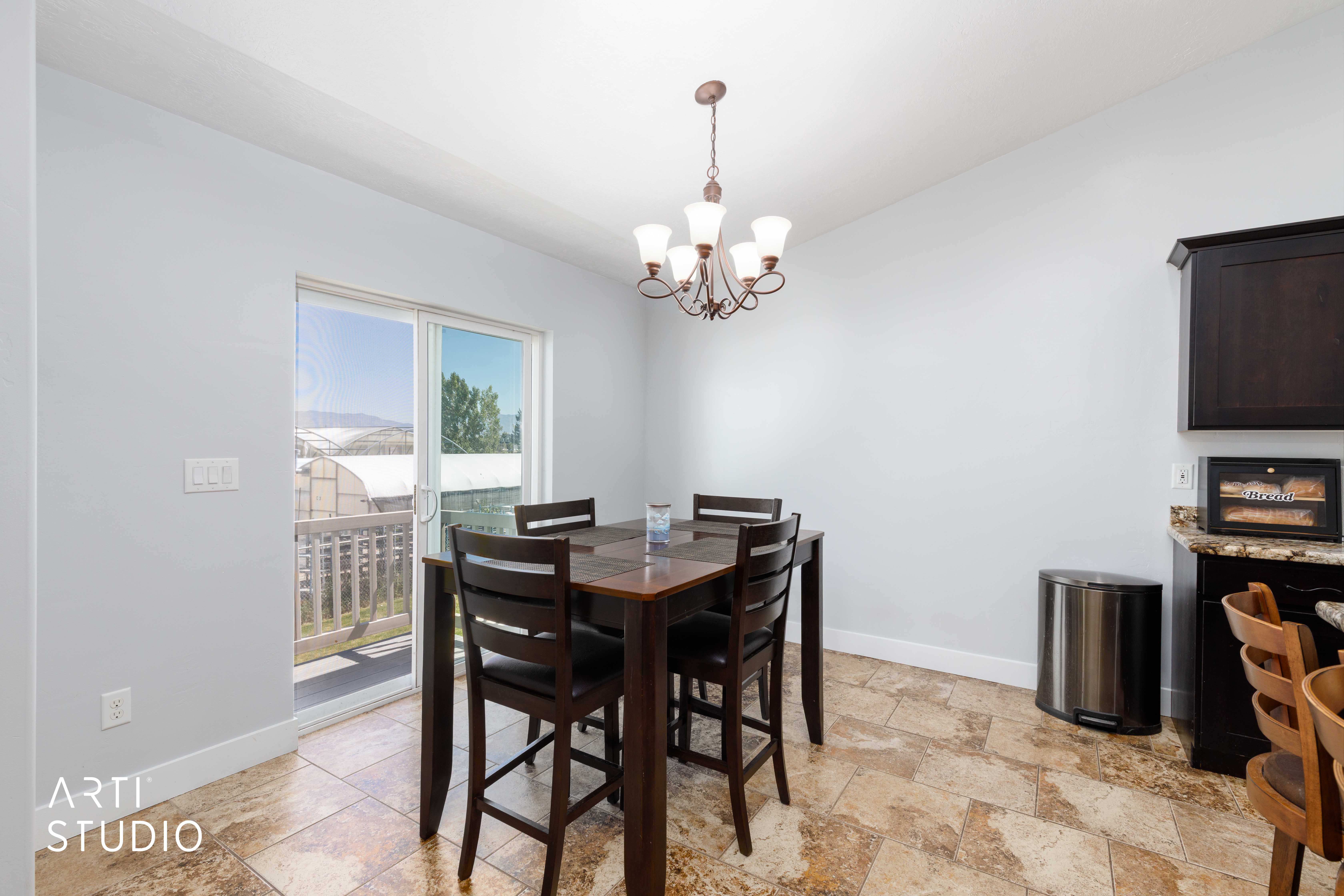 Dining area featuring patterned tile flooring, a sliding glass door with exterior deck access, and a bronze chandelier