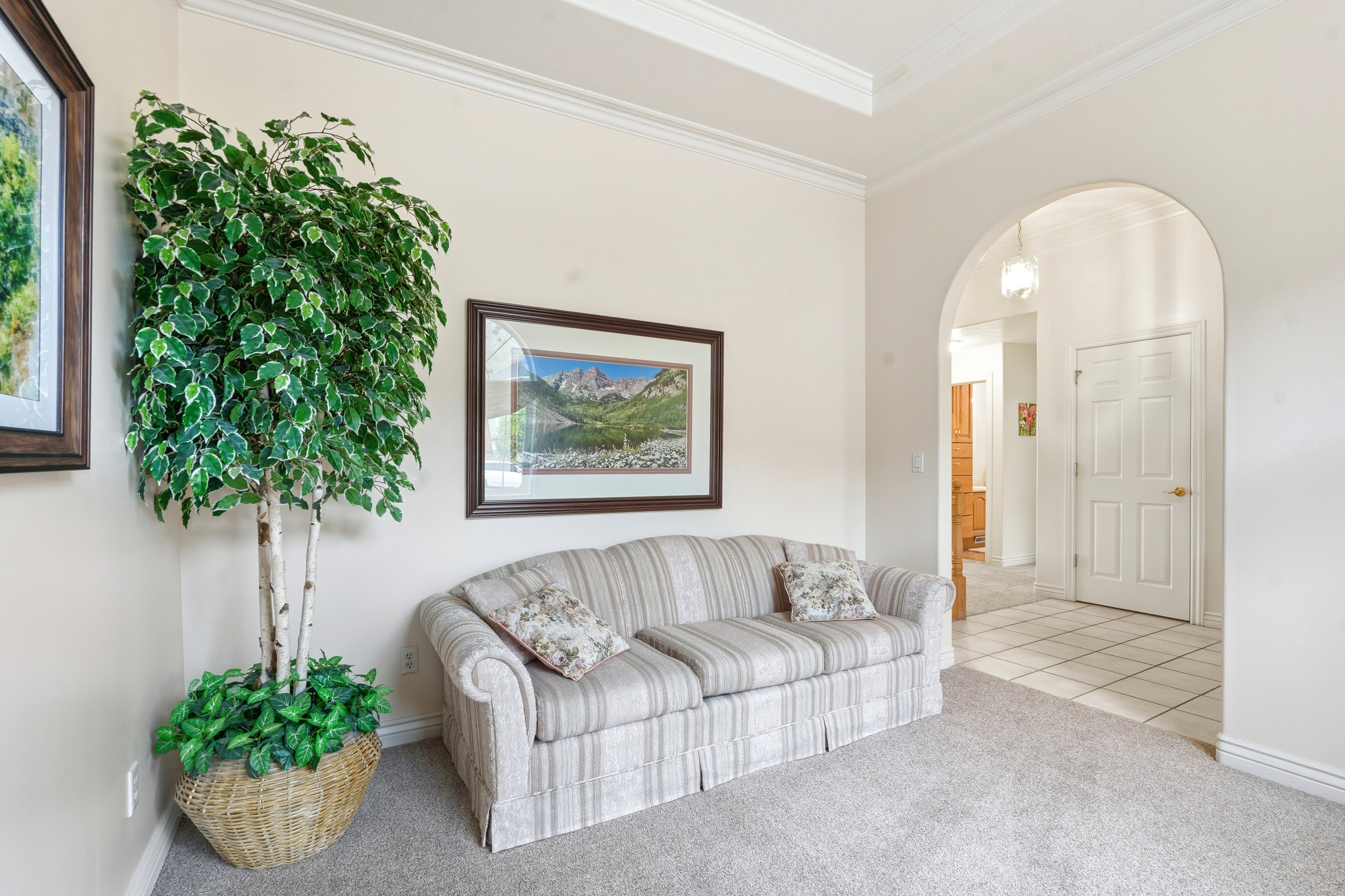 Archway opening to a tiled hallway, featuring a neutral color palette
