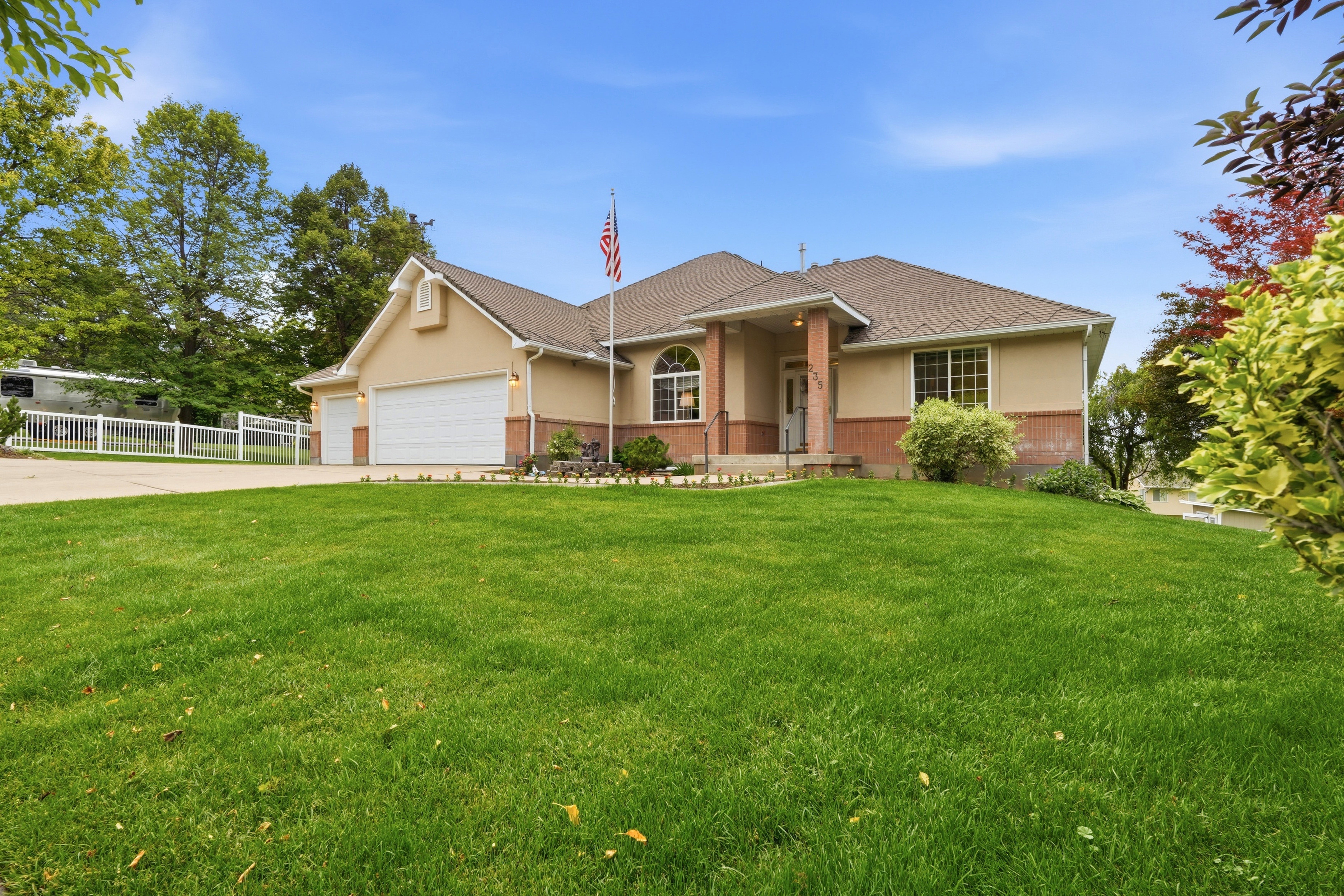 Traditional-style residence featuring a stucco and brick exterior, a two-car garage, and a covered front entry