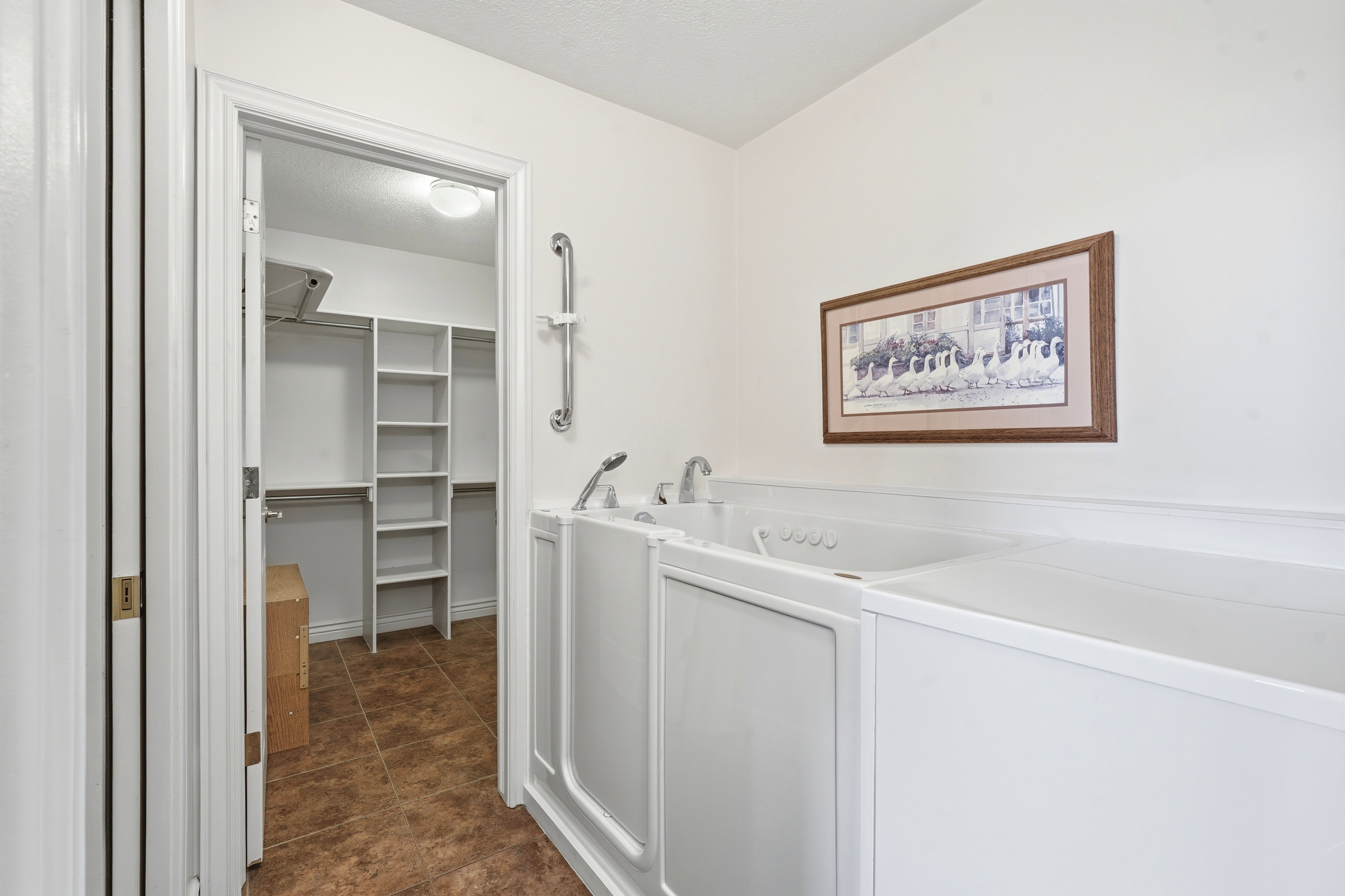 White walk-in tub with chrome fixtures and grab bar