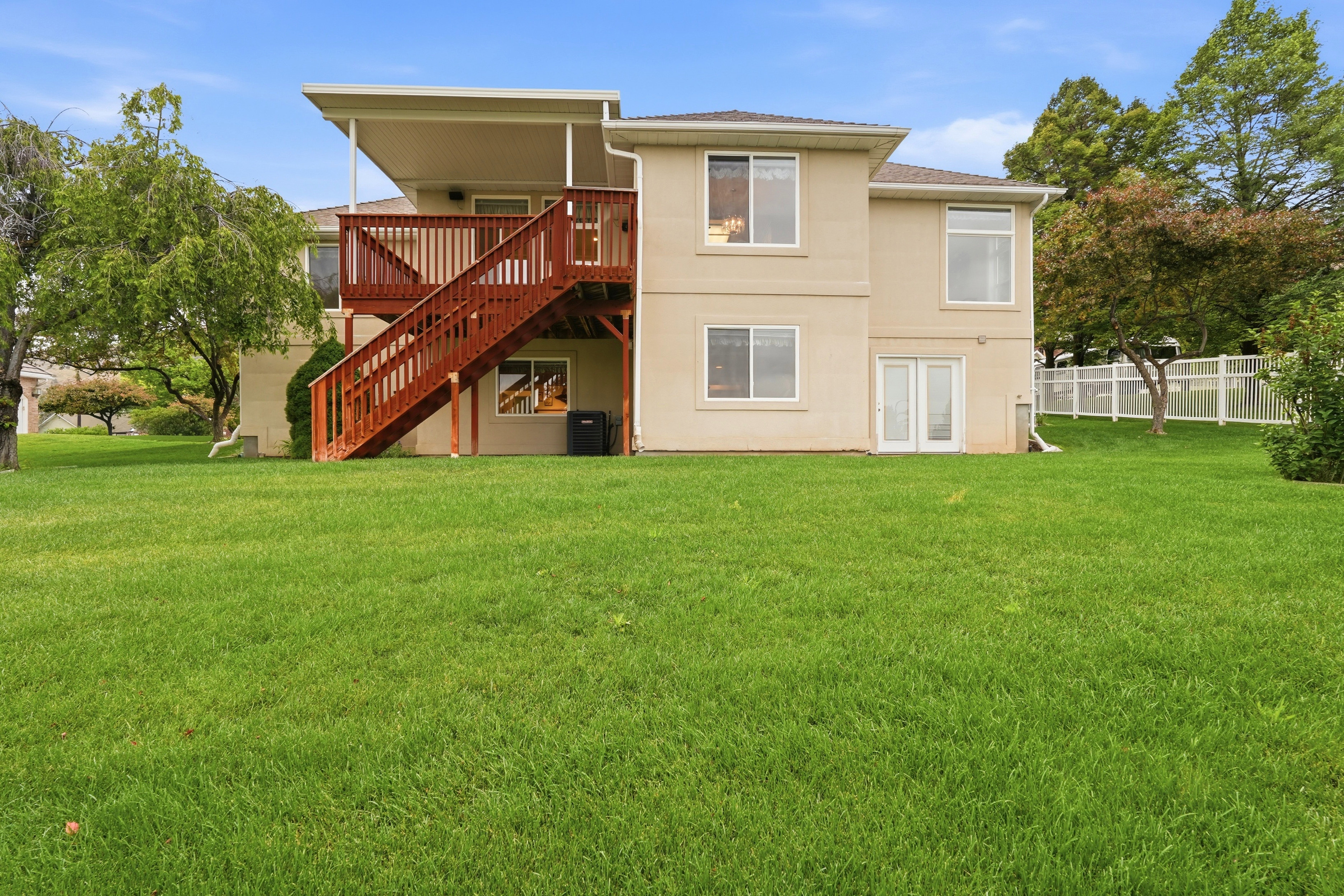 Expansive green lawn bordering a two-story stucco exterior