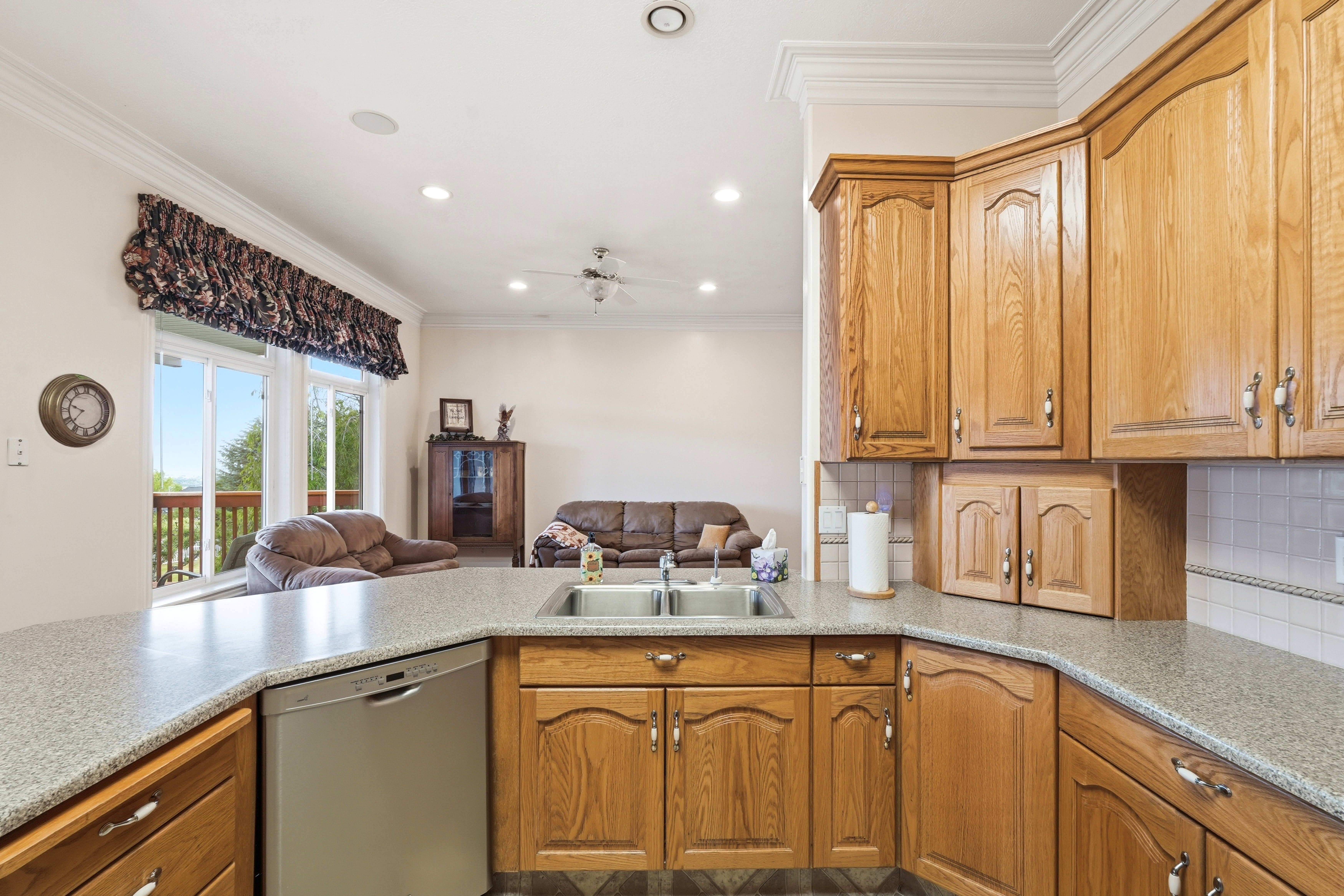 Kitchen featuring wood cabinetry, speckled countertops, and a double basin sink