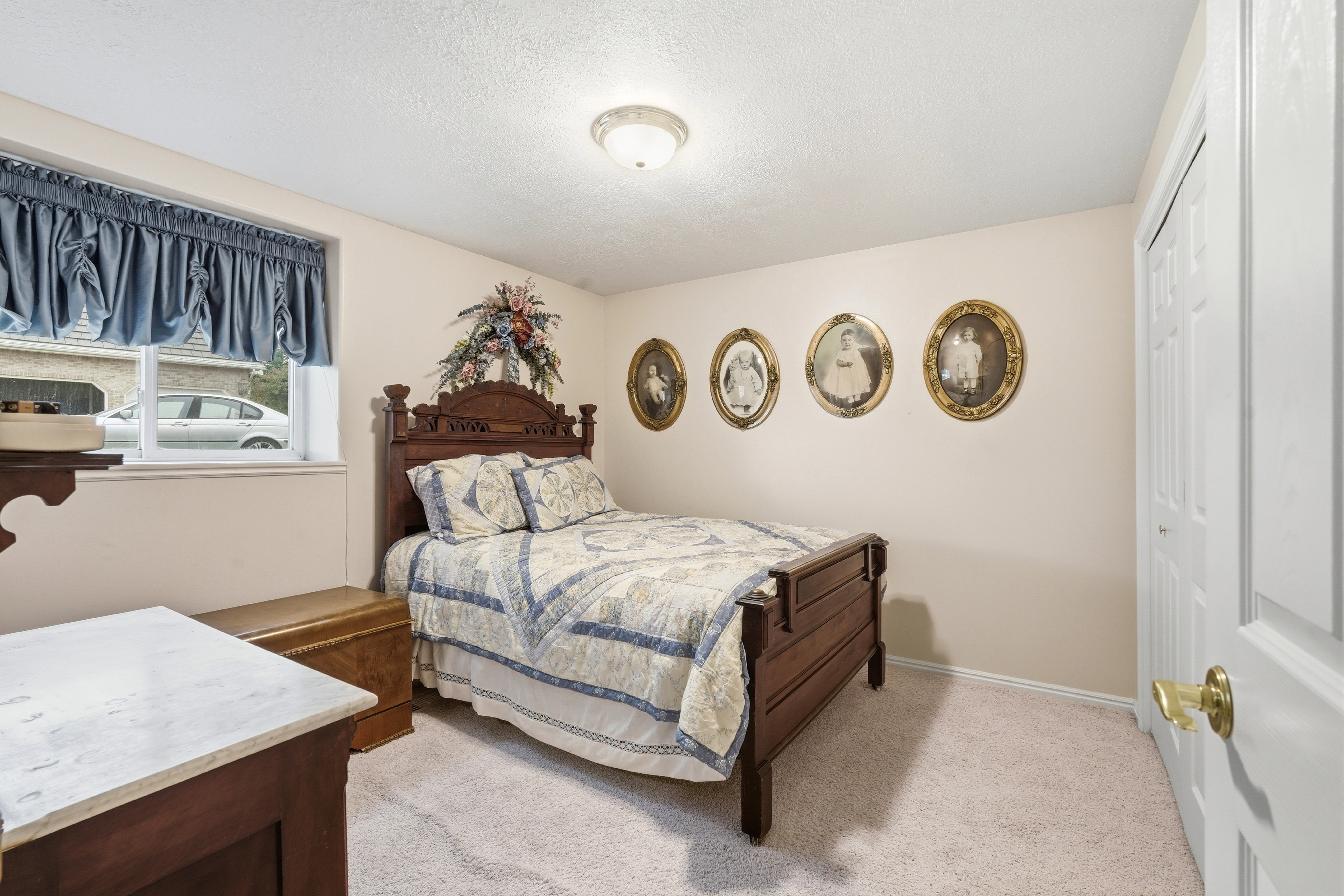 Bright room featuring a window with blue valance, neutral wall paint, and white trim