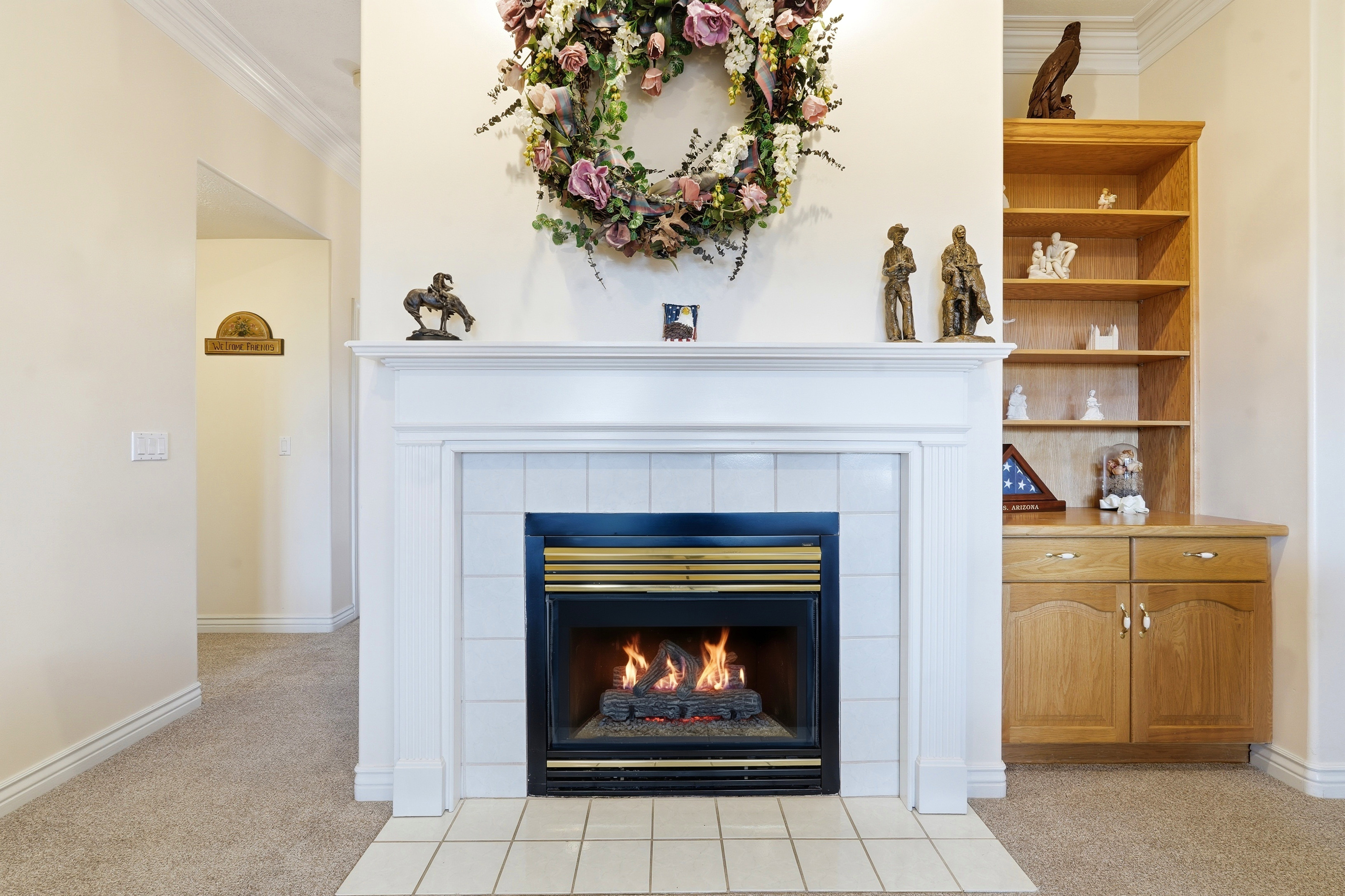 Fireplace featuring a white mantel, tile surround, and an integrated gas insert