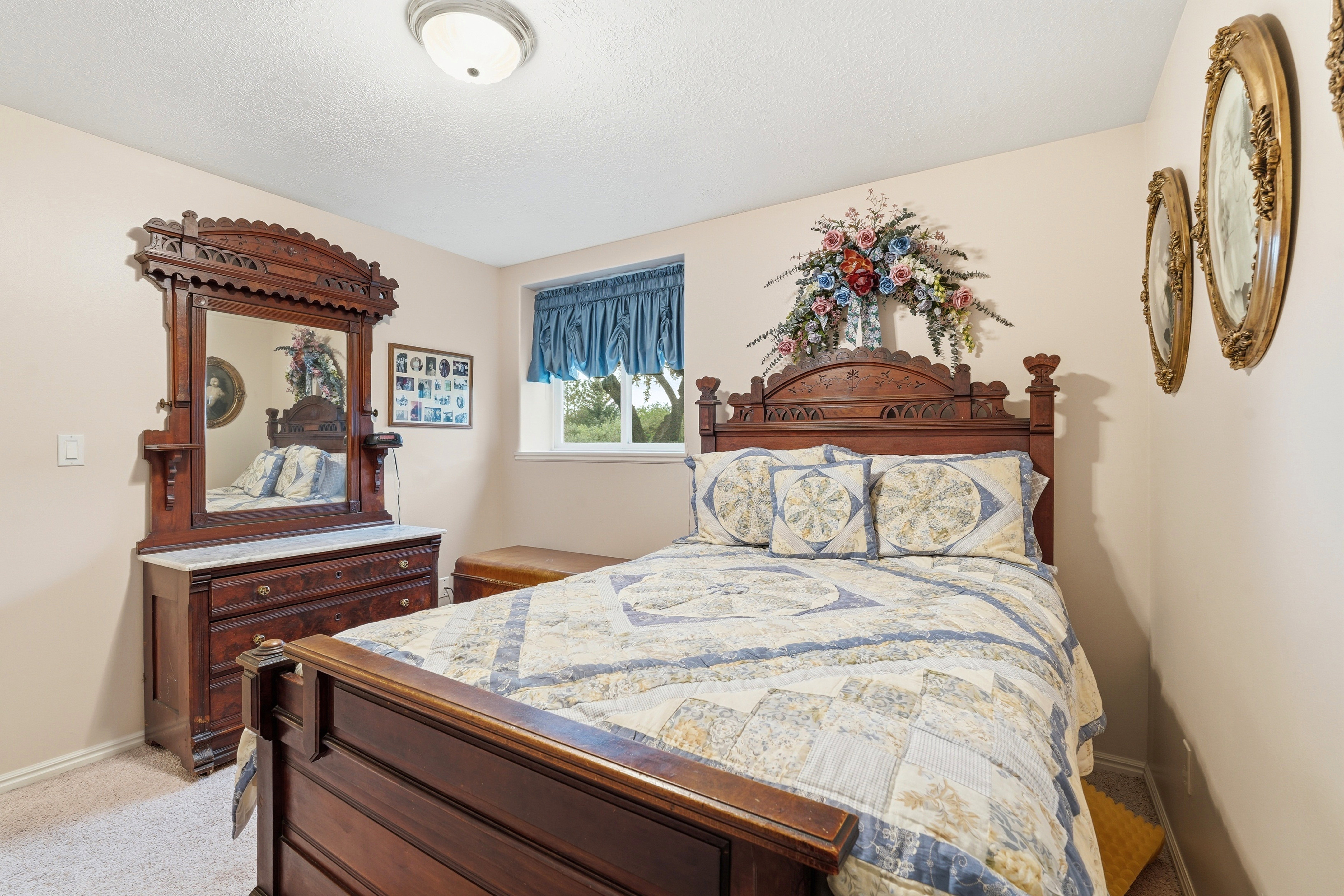 Carpeted room featuring a single window with blue valance