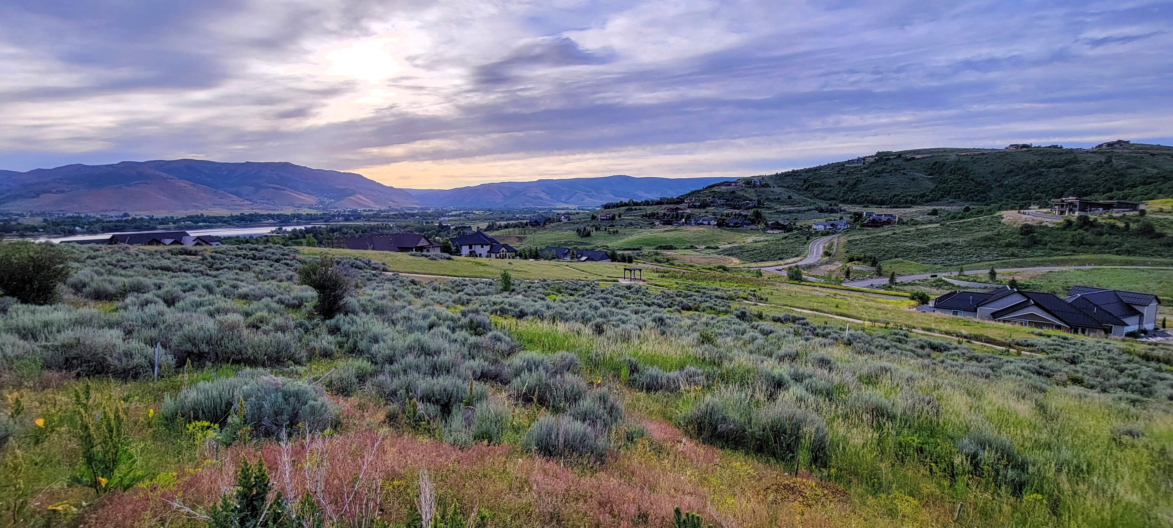 Expansive landscape featuring rolling hills and distant mountains
