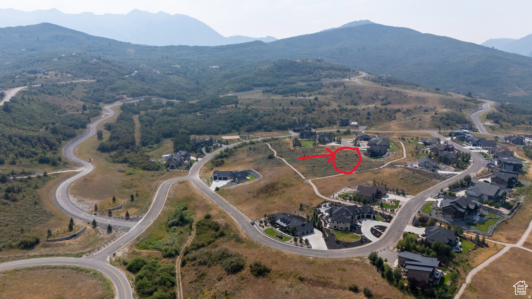 Expansive mountainous landscape with paved roads and scattered residential properties