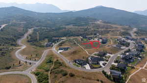 Expansive mountainous landscape with paved roads and scattered residential properties