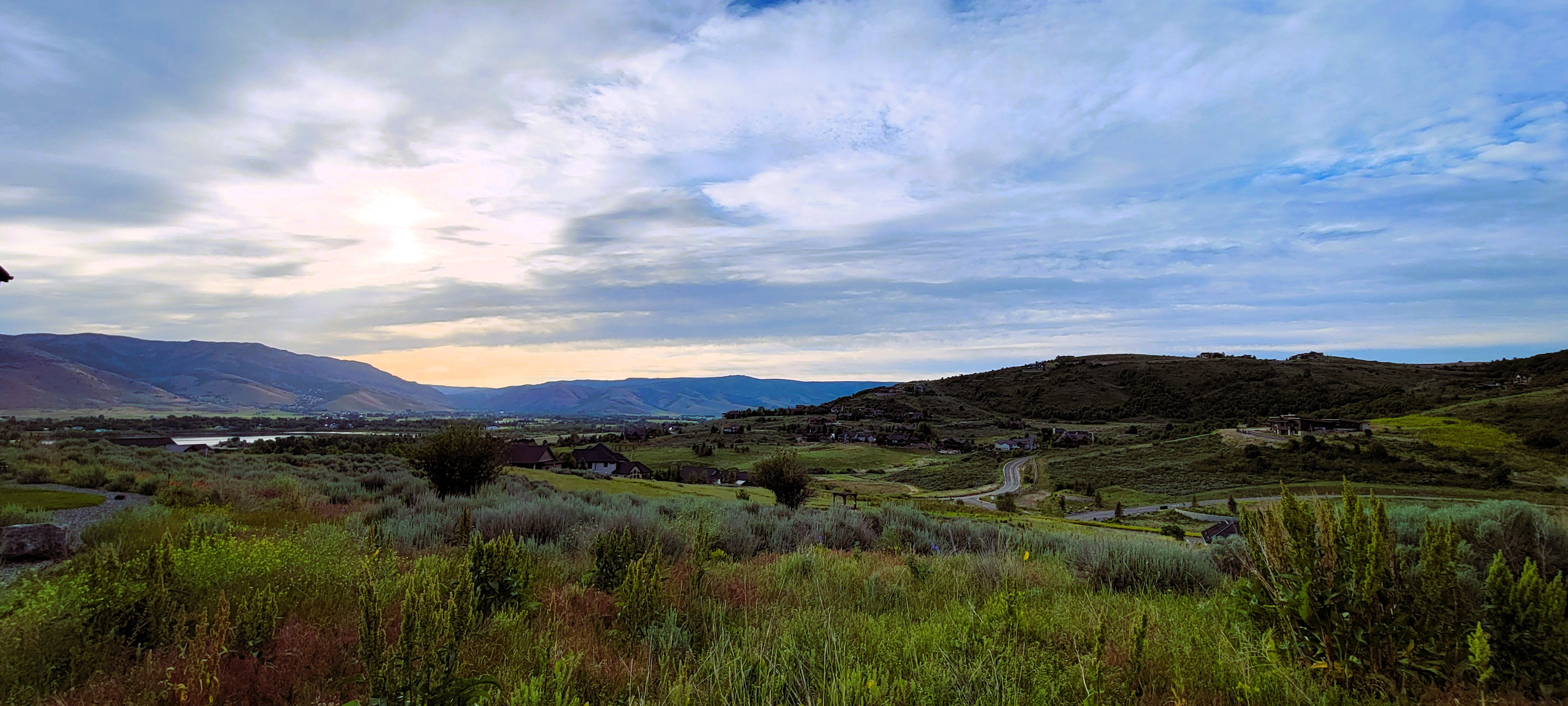 Expansive mountain and valley landscape with distant water features