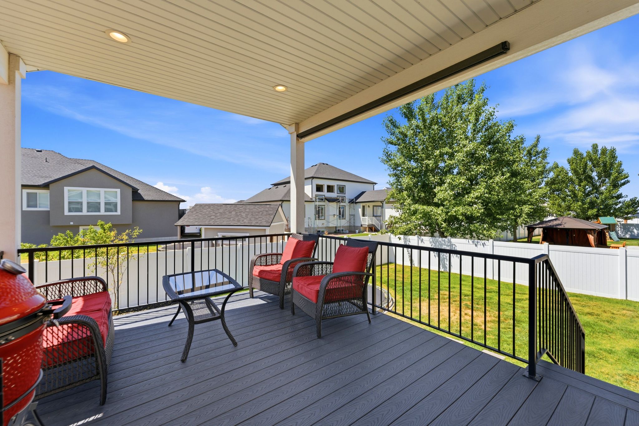 Covered deck with recessed lighting and staircase to backyard.