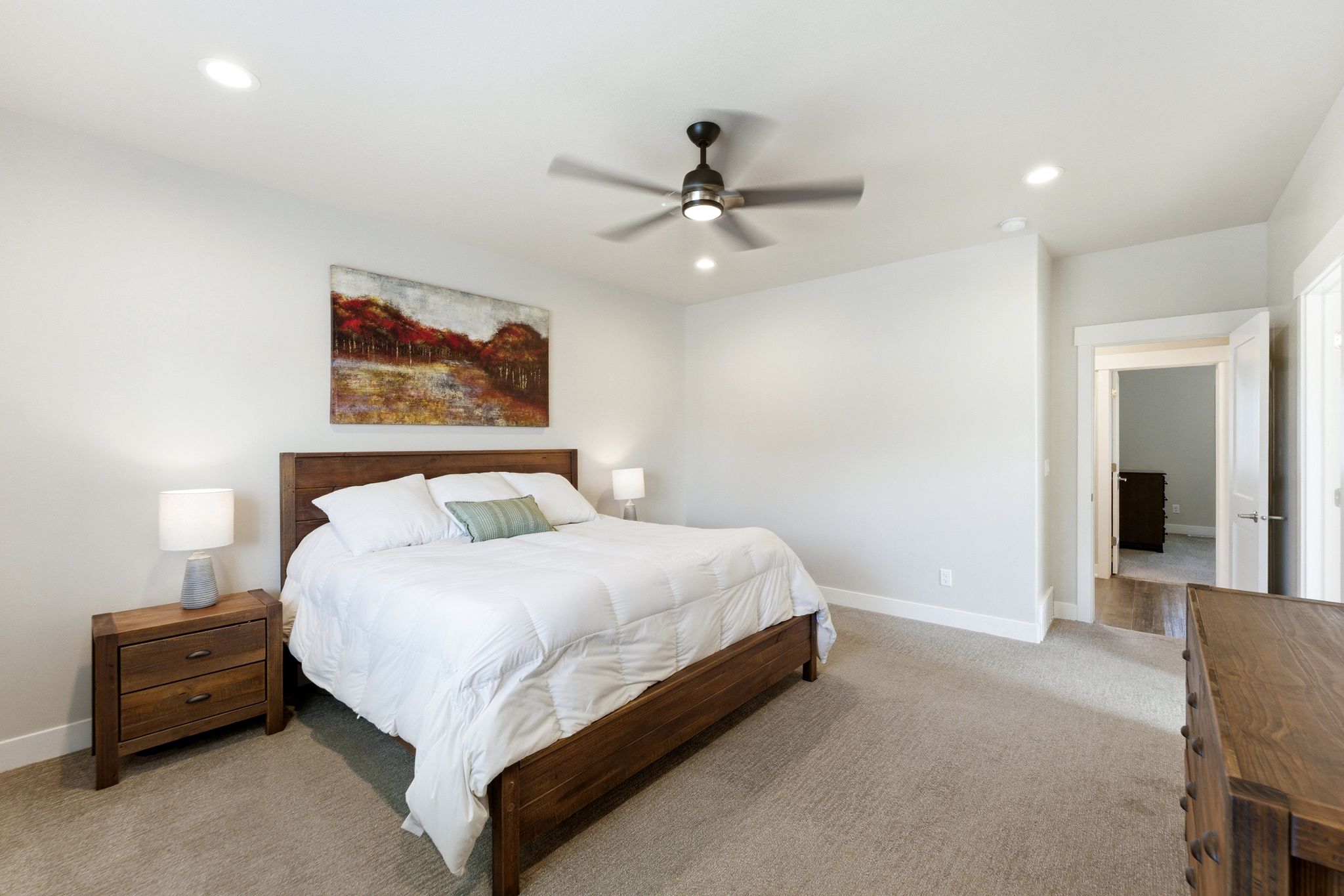 Comfortable primary bedroom with fan and ensuite bathroom.