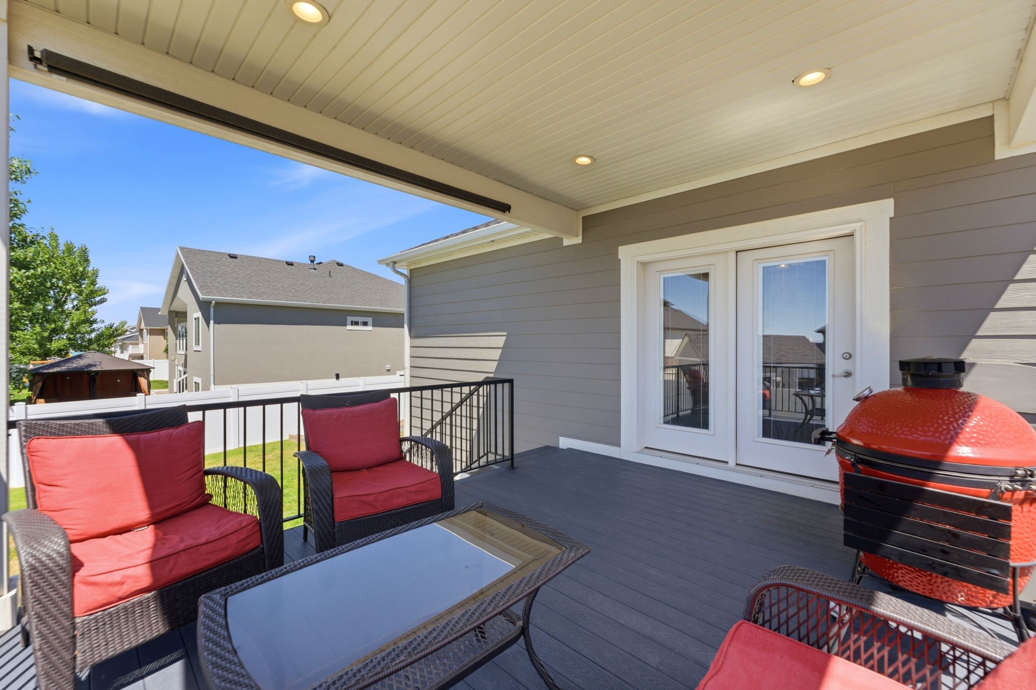 Covered deck with recessed lighting and staircase to backyard.