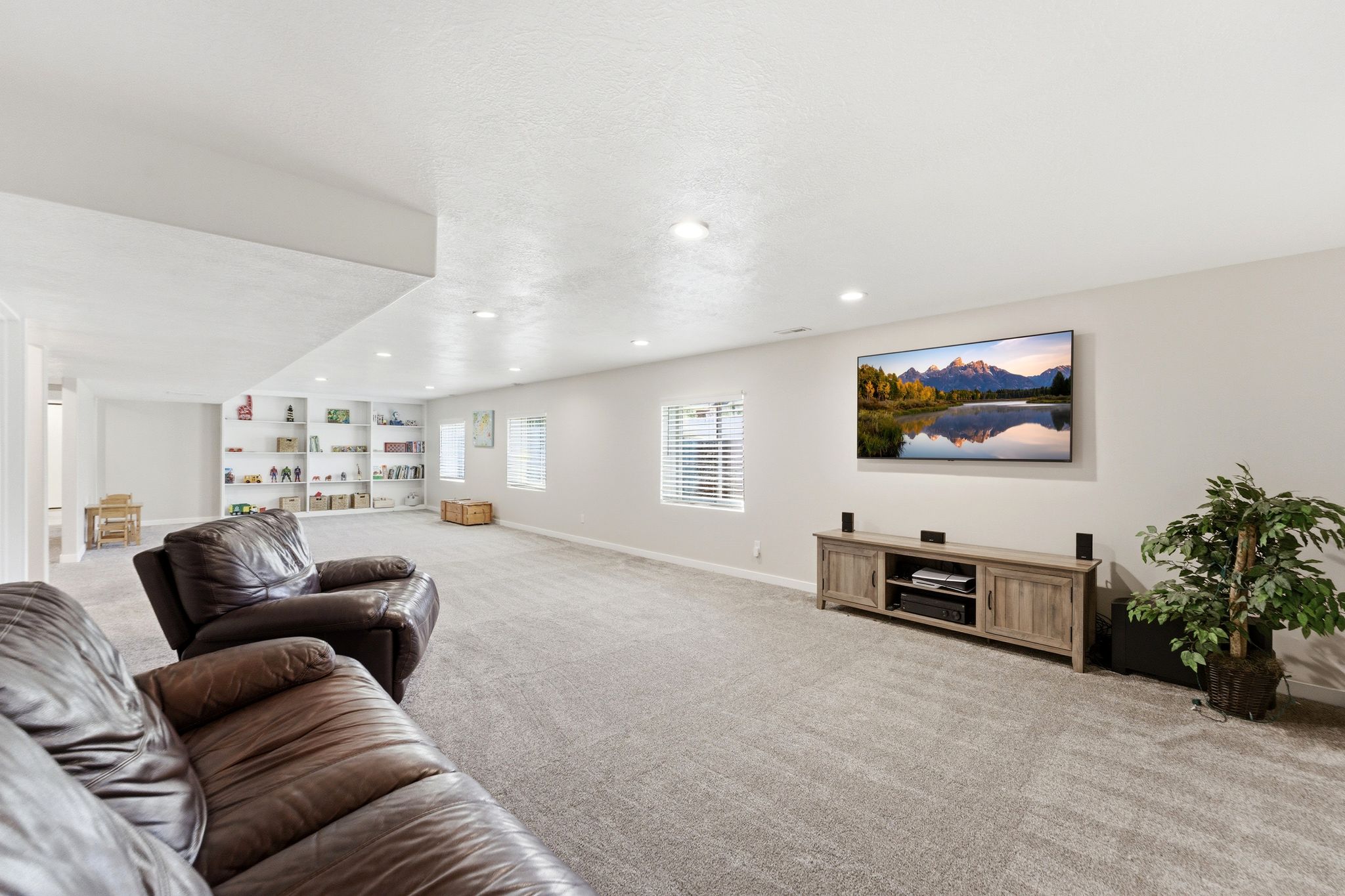 Spacious entertainment area with 3 large windows that bring in lots of light with decorative window wells.