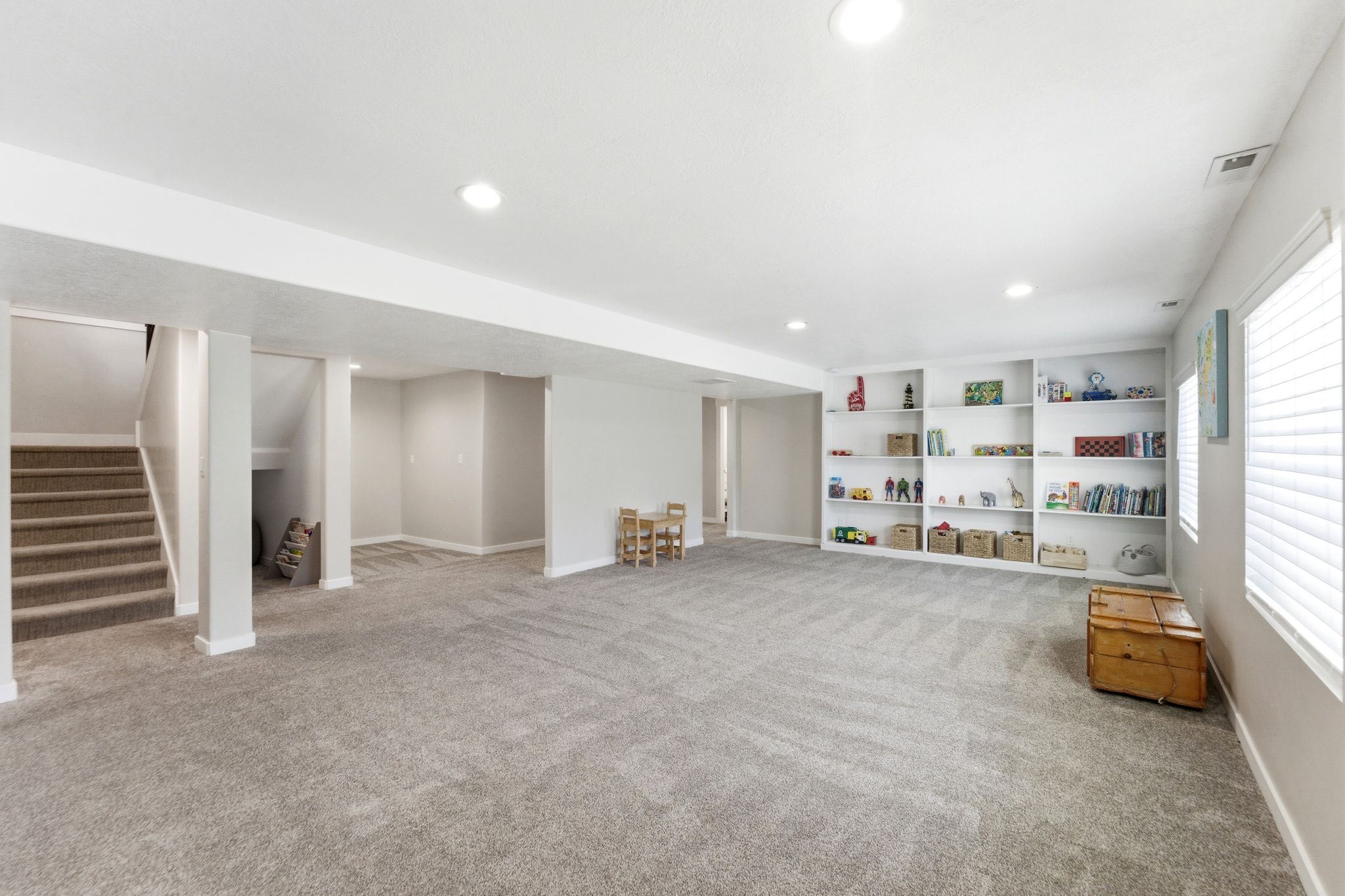 Spacious entertainment area with 3 large windows that bring in lots of light with decorative window wells and built in shelving.