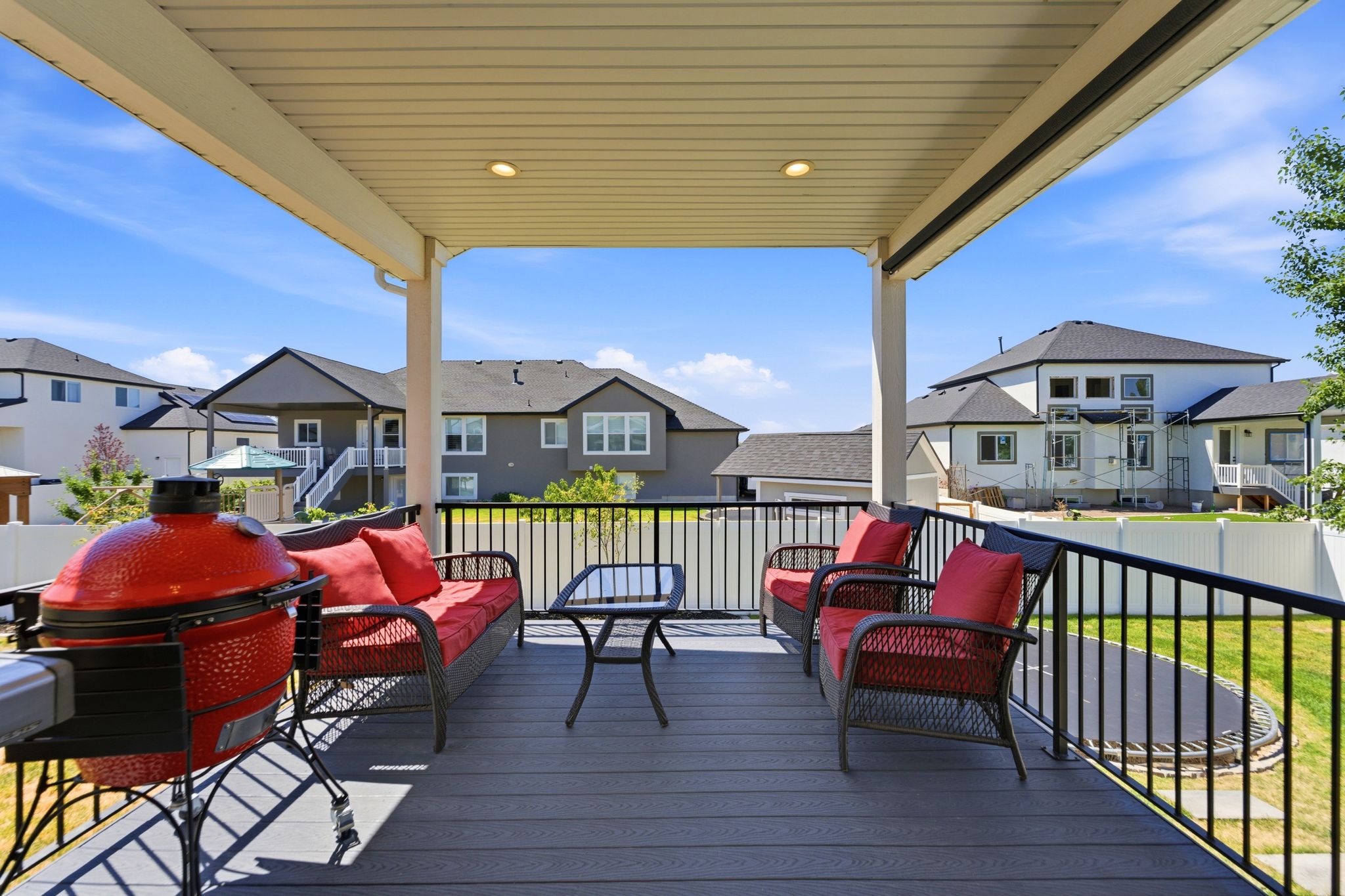 Covered deck with recessed lighting and staircase to backyard.
