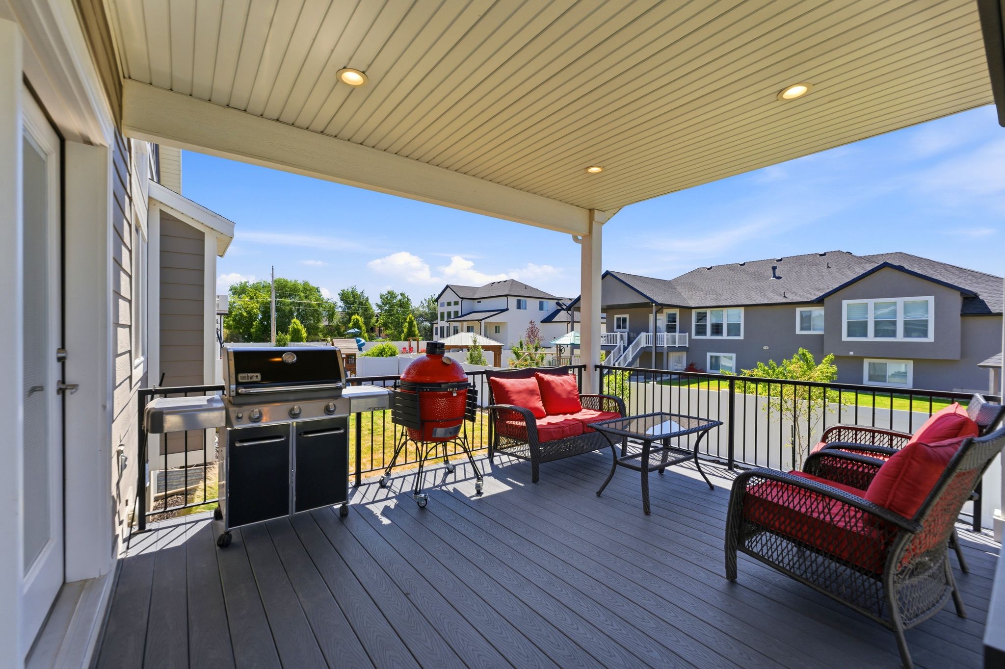 Covered deck with recessed lighting and staircase to backyard.