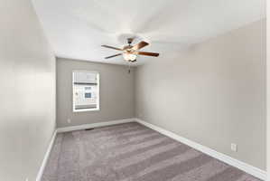 Room featuring light gray walls, textured gray carpeting, white baseboards, and a window with white blinds
