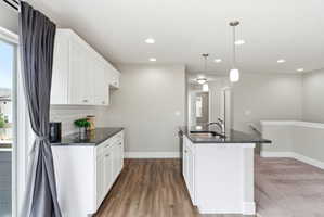 Kitchen featuring white shaker cabinetry, dark stone countertops, and a white subway tile backsplash