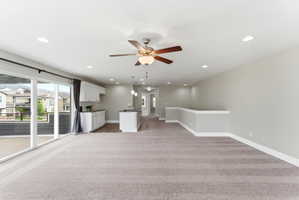 Open-concept living area featuring a neutral color palette, recessed lighting, and a ceiling fan