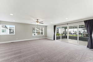 Spacious room featuring neutral carpet flooring, recessed lighting, and a ceiling fan